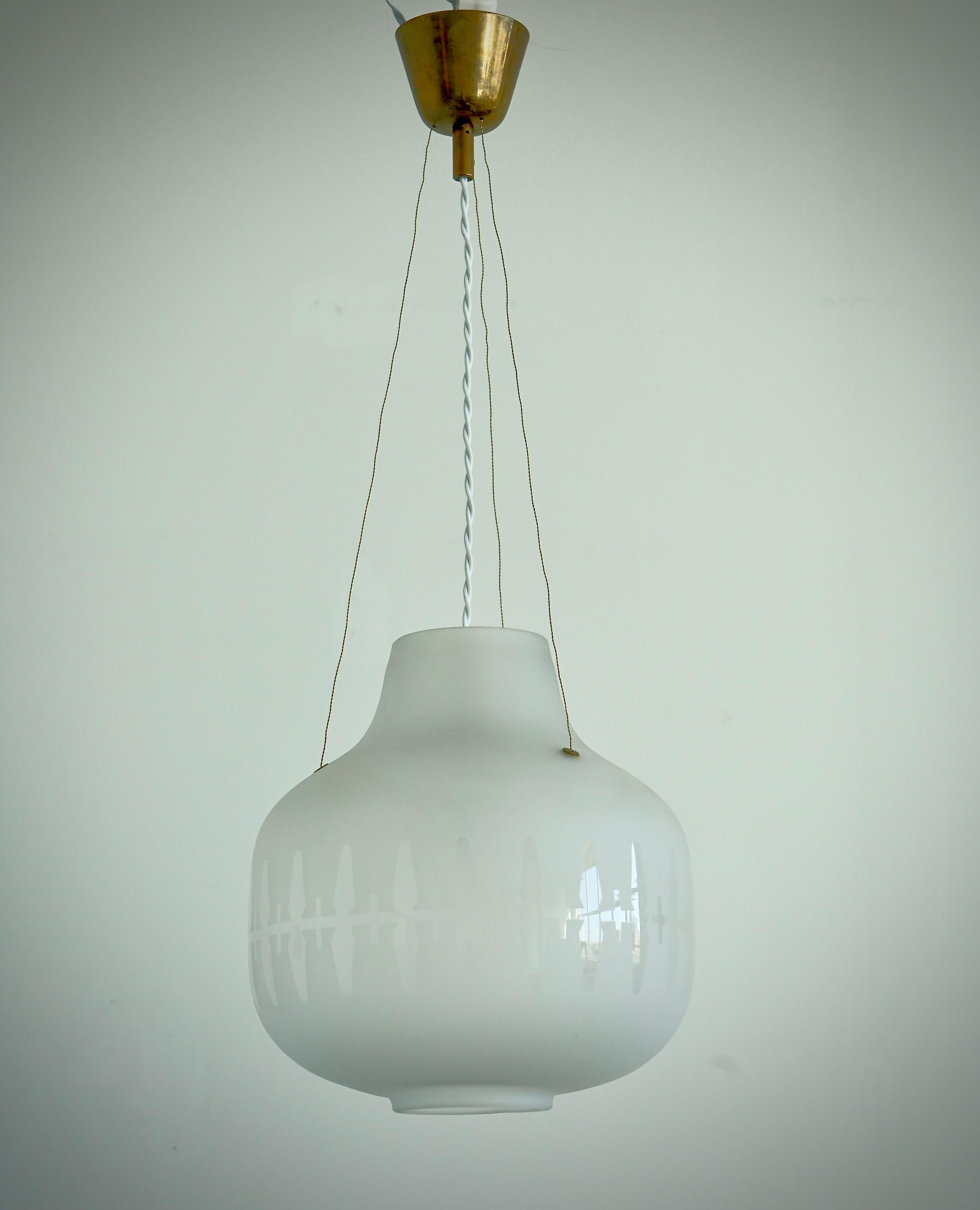 Suspension conçue par Harald Notini pour Arvid Böhlmarks Lampfabrik, modèle 11868. Stockholm, années 1950.
Abat-jour doublement gravé avec décoration claire, suspension en laiton. Hauteur de l'abat-jour 12.6