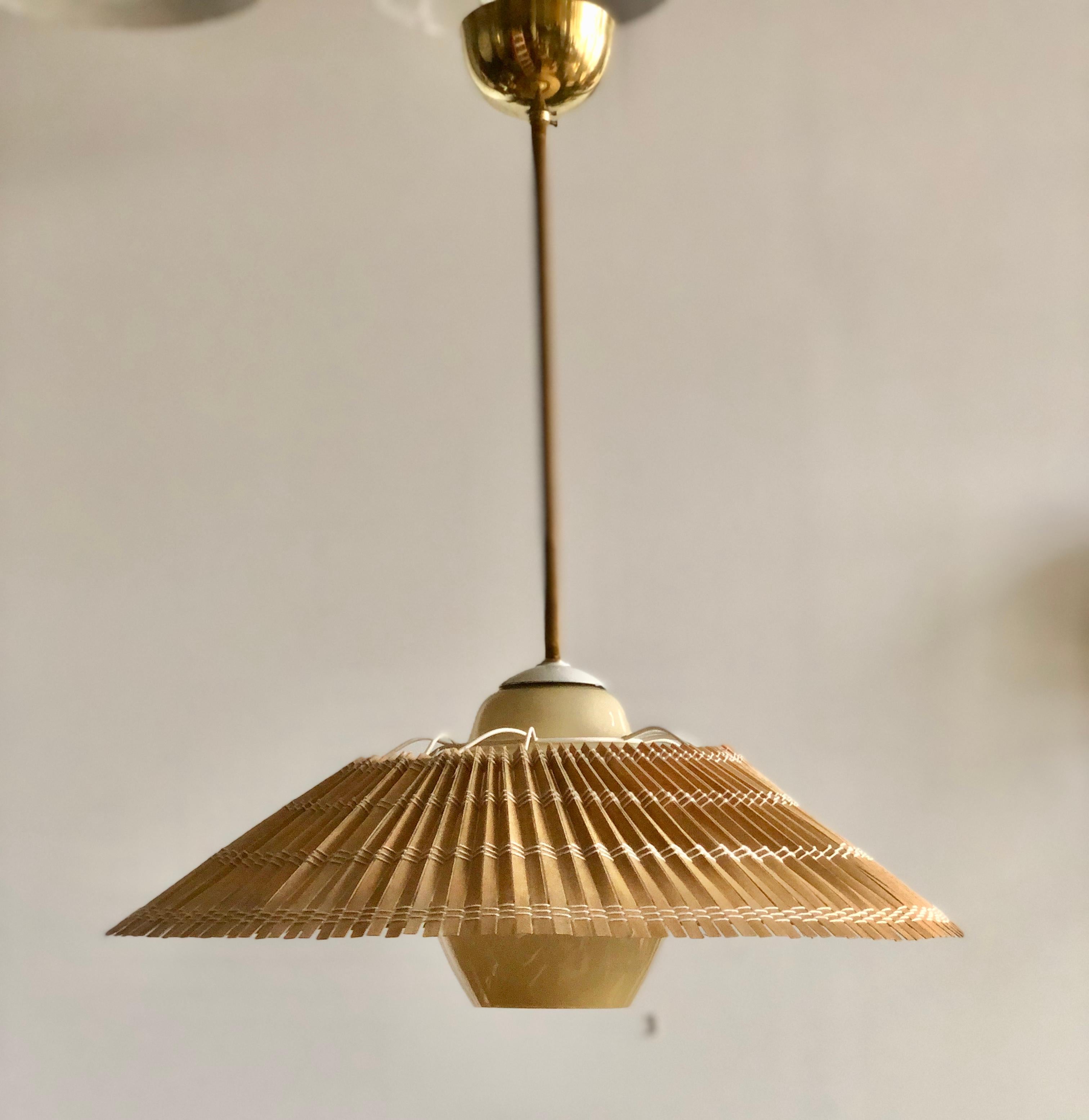 Lighting pendant designed by Lisa Johansson-Pape for Orno, Finland , circa 1950th. Model number 1045.
Glass shade with wooden slots shade and wrapped in fabric wire stem. Existing wires, rewiring available upon request.