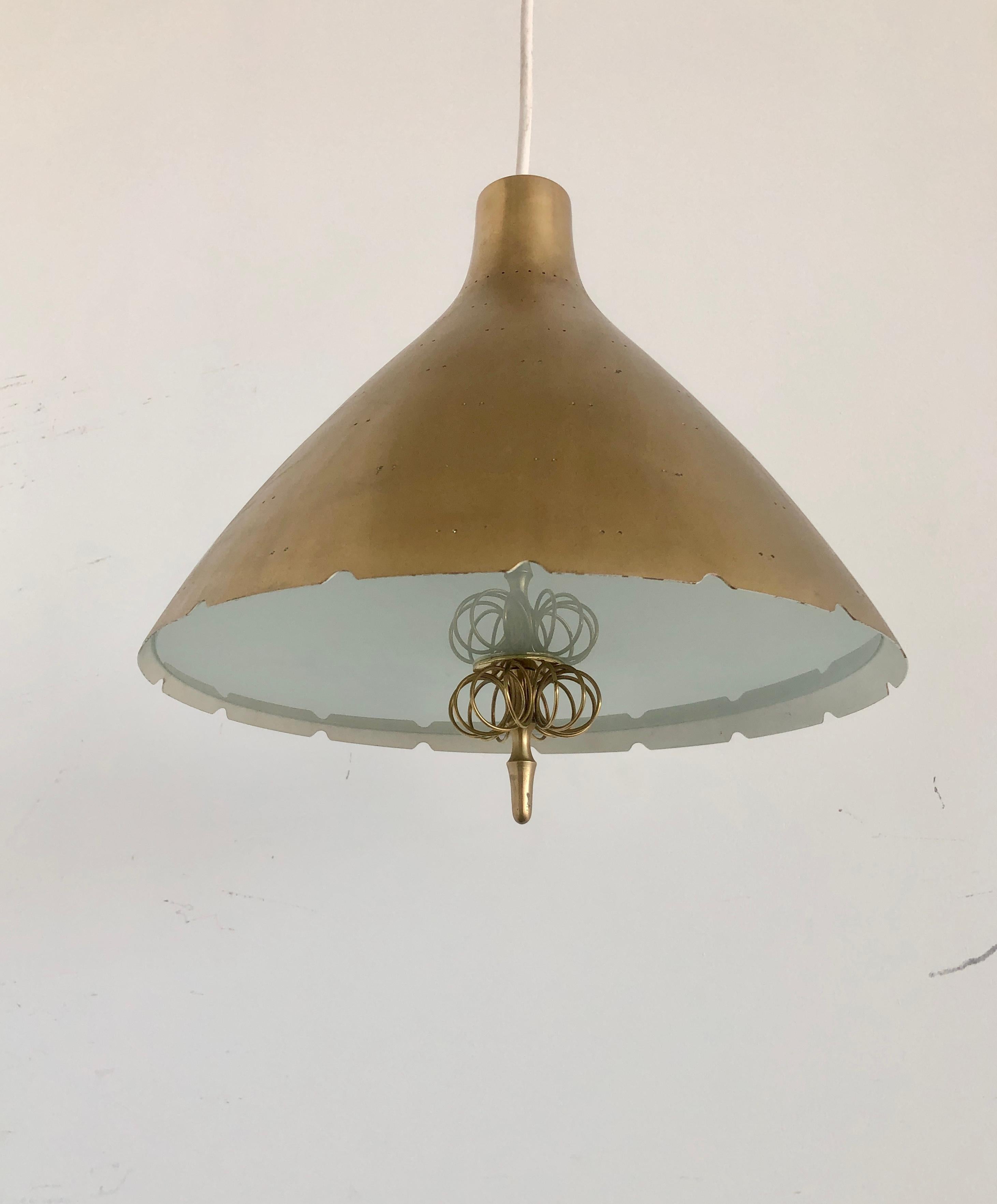 A large lighting pendant Model K2-46 designed by Paavo Tynell for Idman, Finland, Circa 1950th. The perforated brass shade, a etched glass diffuser underneath with wire brass decor. The overall drop can be adjusted. Natural patina on brass. Rewiring