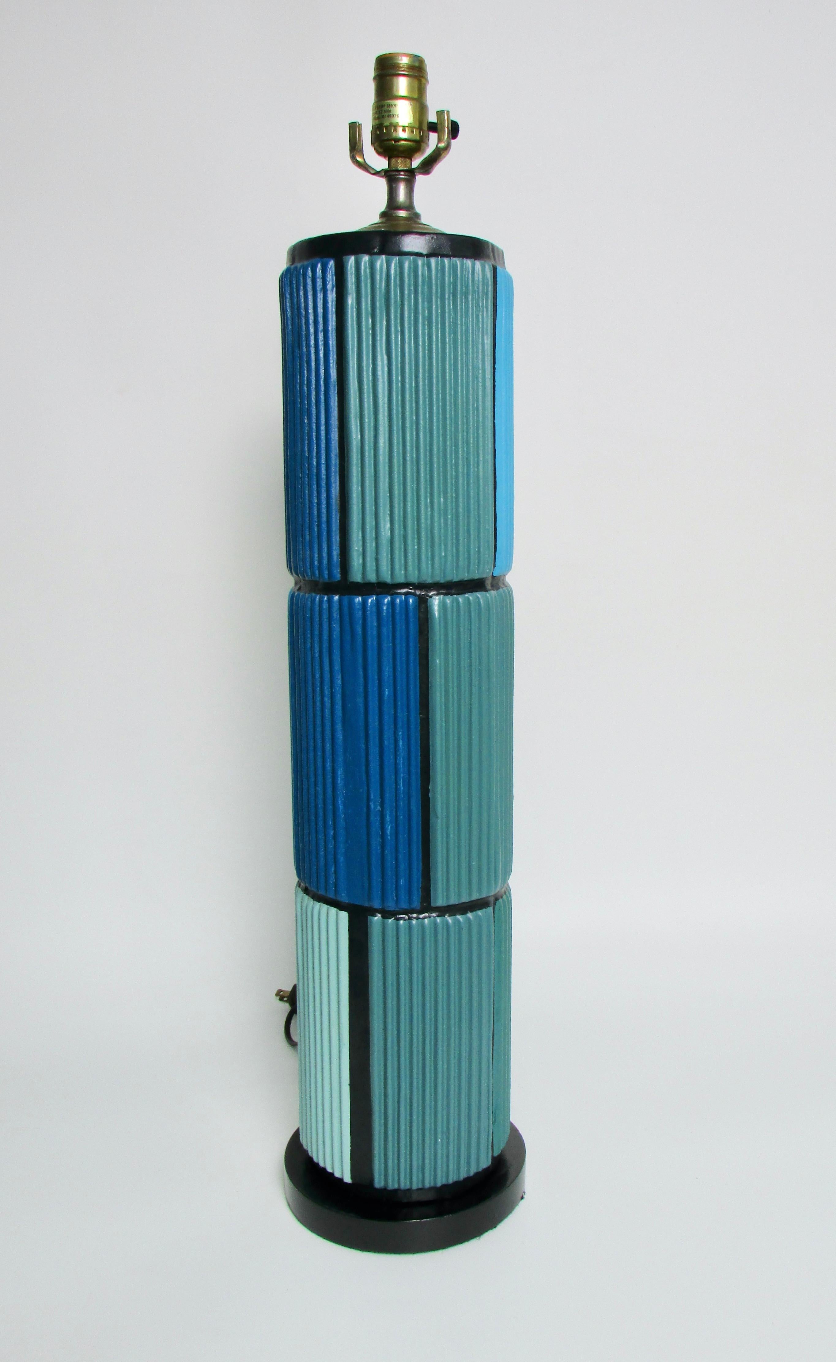Tall cylindrical table lamp . Painted Mondrian style in shades of blue . Base has 6.5