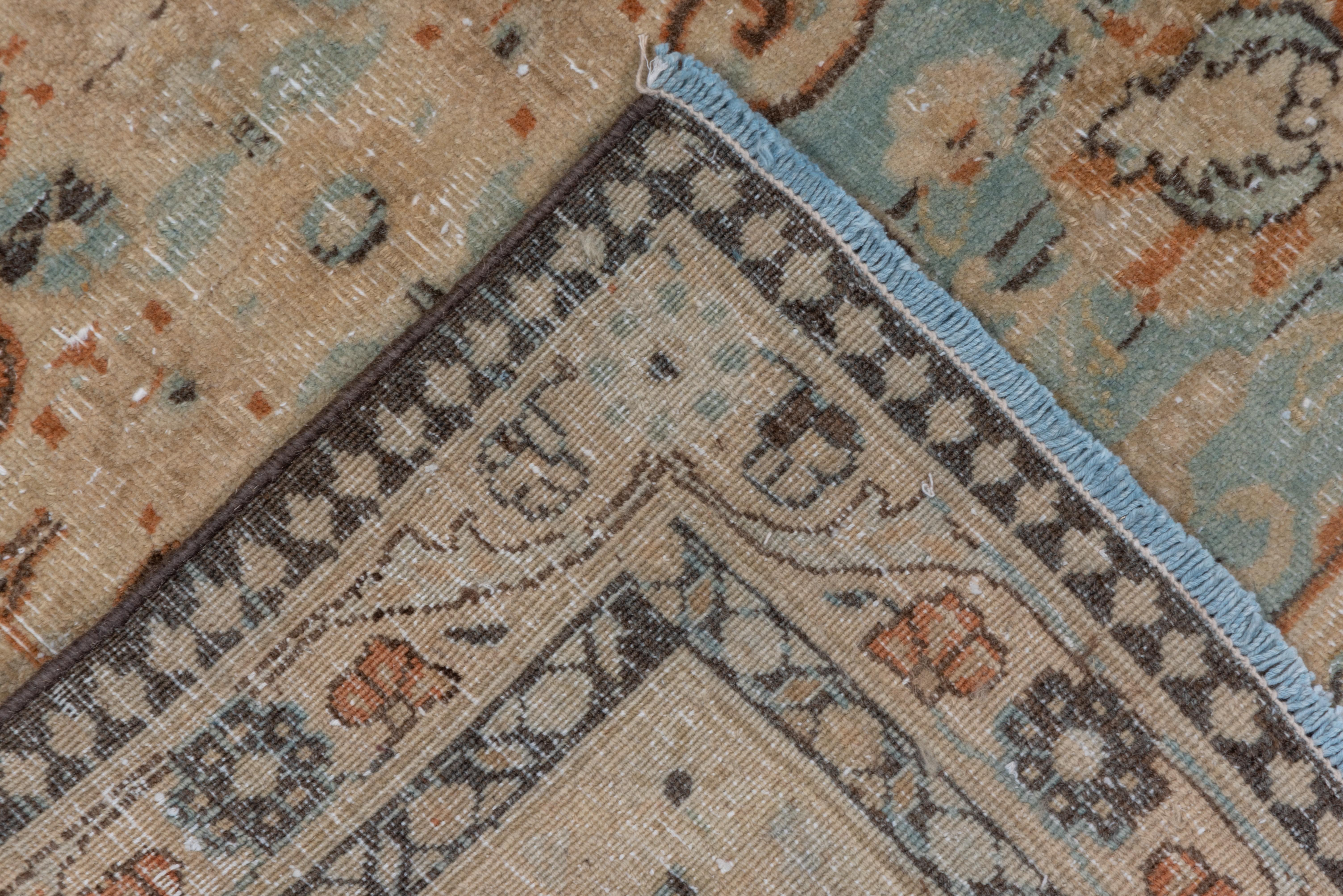 The visibly abrashed pale blue-grey field of this NE Persian city carpet shows five rows of three or two voluted cruciform lozenges, all set off by a sand palmette border. Partially distressed.