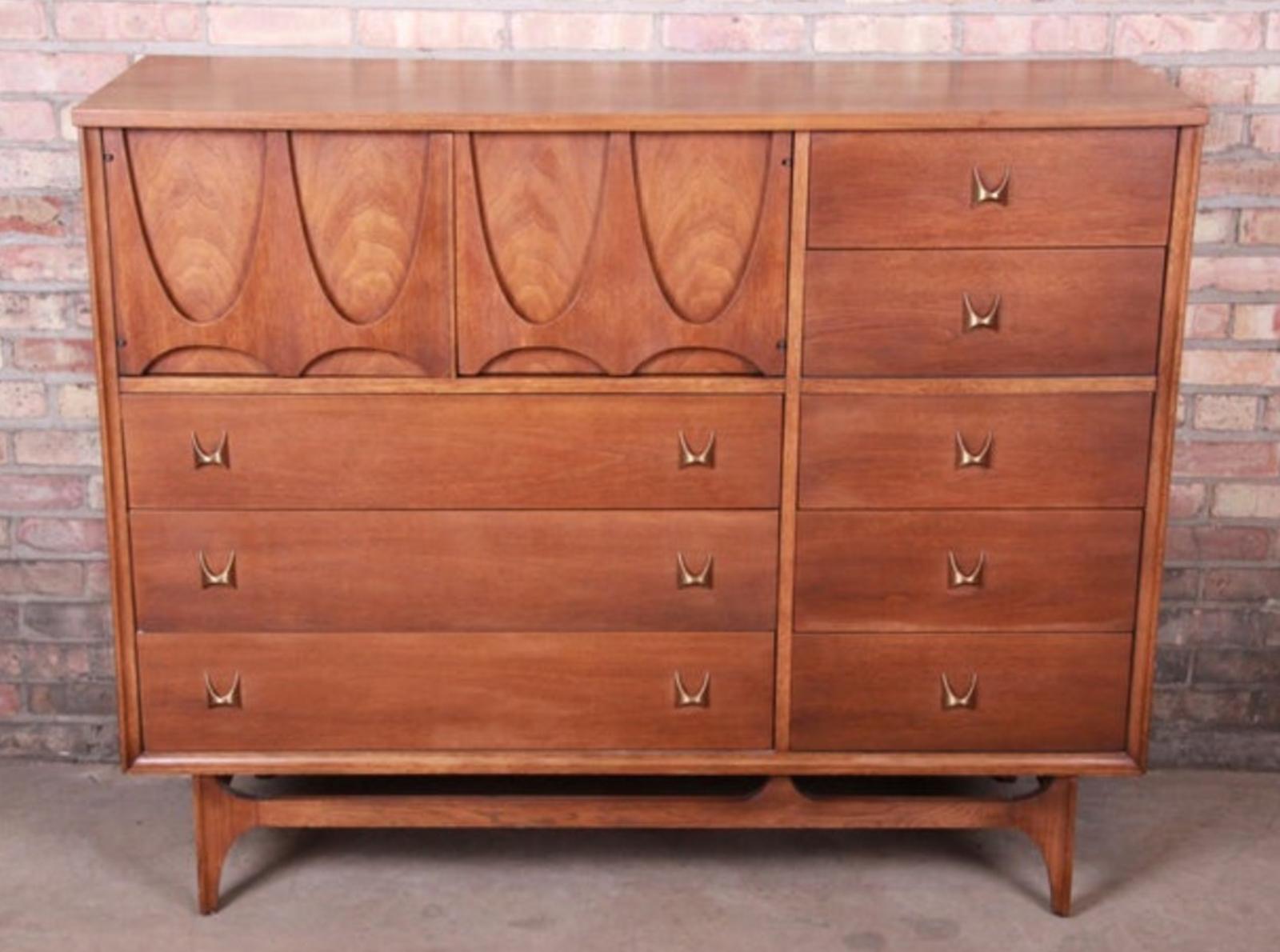 This fantastic tall chest was built in the 1970s by high-end manufacturer Broyhill for their Brasilia line of furntiure. Since then, the Brasilia line has become more desirable, and original sets are difficult to come by. Featuring walnut
