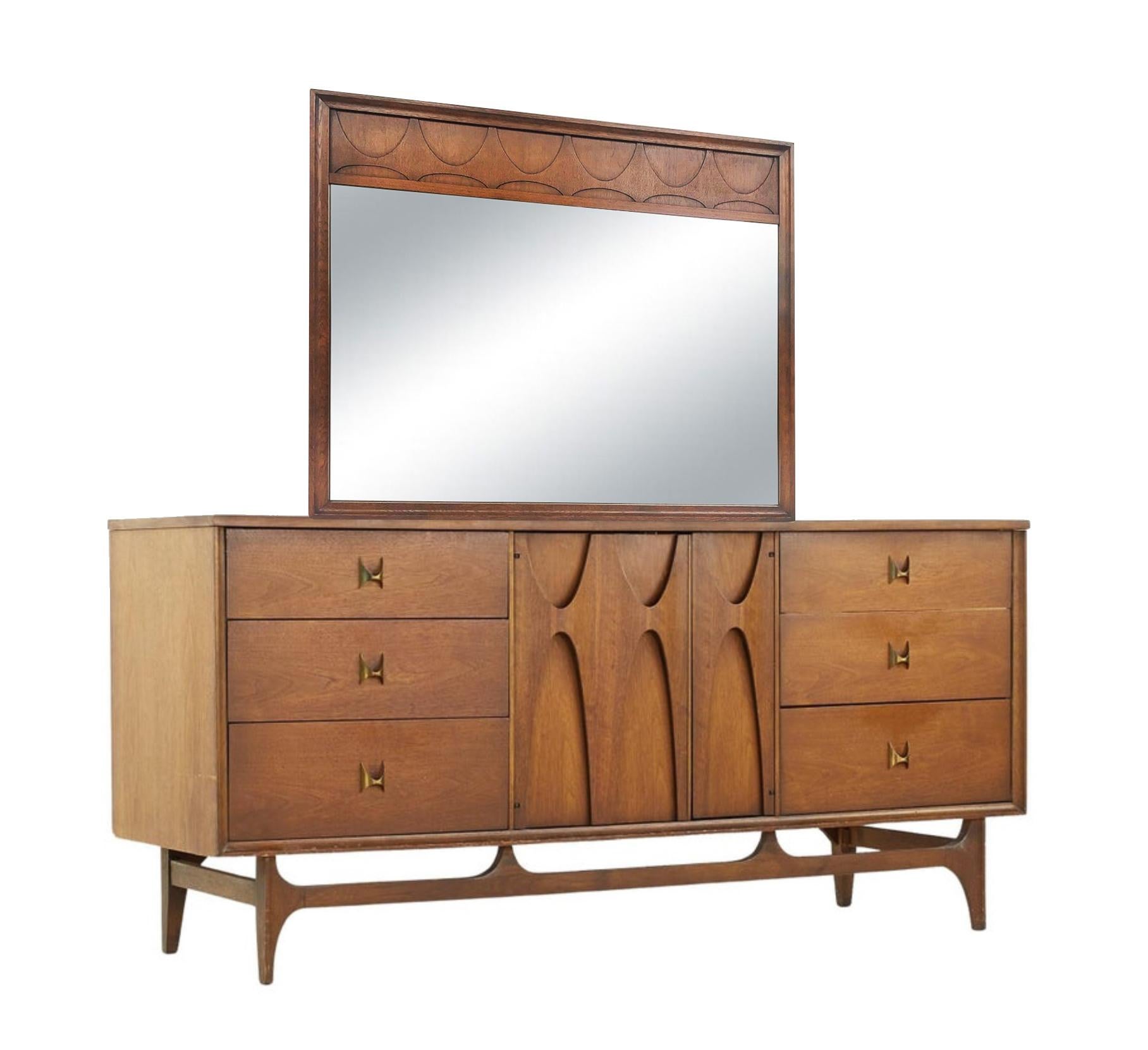 This fantastic long dresser & mirror combo was built in the 1970s by high-end manufacturer Broyhill for their Brasilia line of furntiure. Since then, the Brasilia line has become more desirable, and original sets are difficult to come by. Featuring