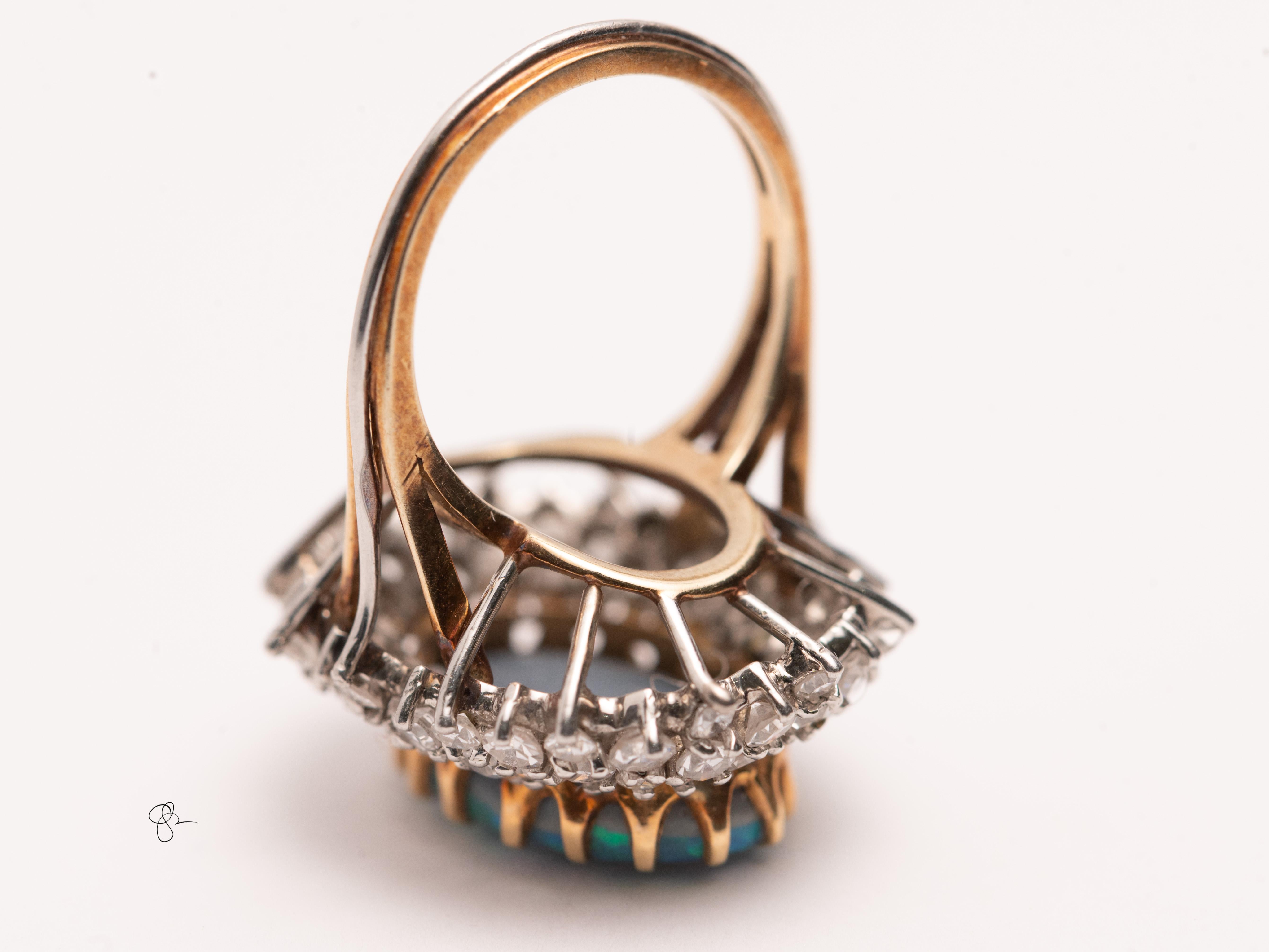 Questo anello da cocktail con opale e diamanti Lightning Ridge è un pezzo straordinario, che mette in mostra un grande opale ovale vivo con lampi iridescenti di verde, blu e turchese. L'ipnotico gioco di colori è un tratto distintivo dell'opale