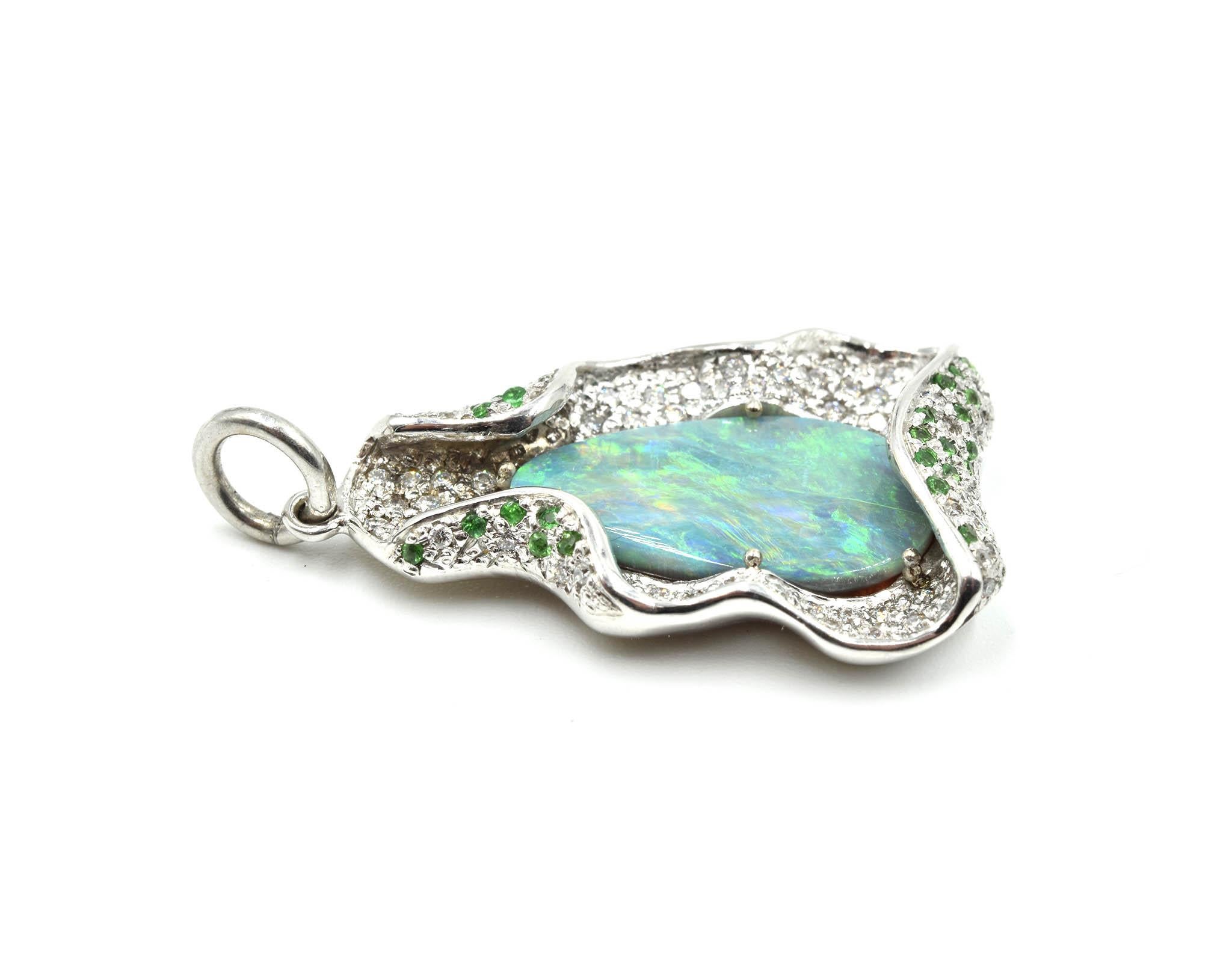 This 14k white gold custom-made pendant features a rare lightning ridge opal. The opal is prong set in the immense play-of-color. There are 0.18cttw of tsavorites and 0.90cttw of diamonds. The lightning ridge opal measures 18.52mmx10.52mm. The