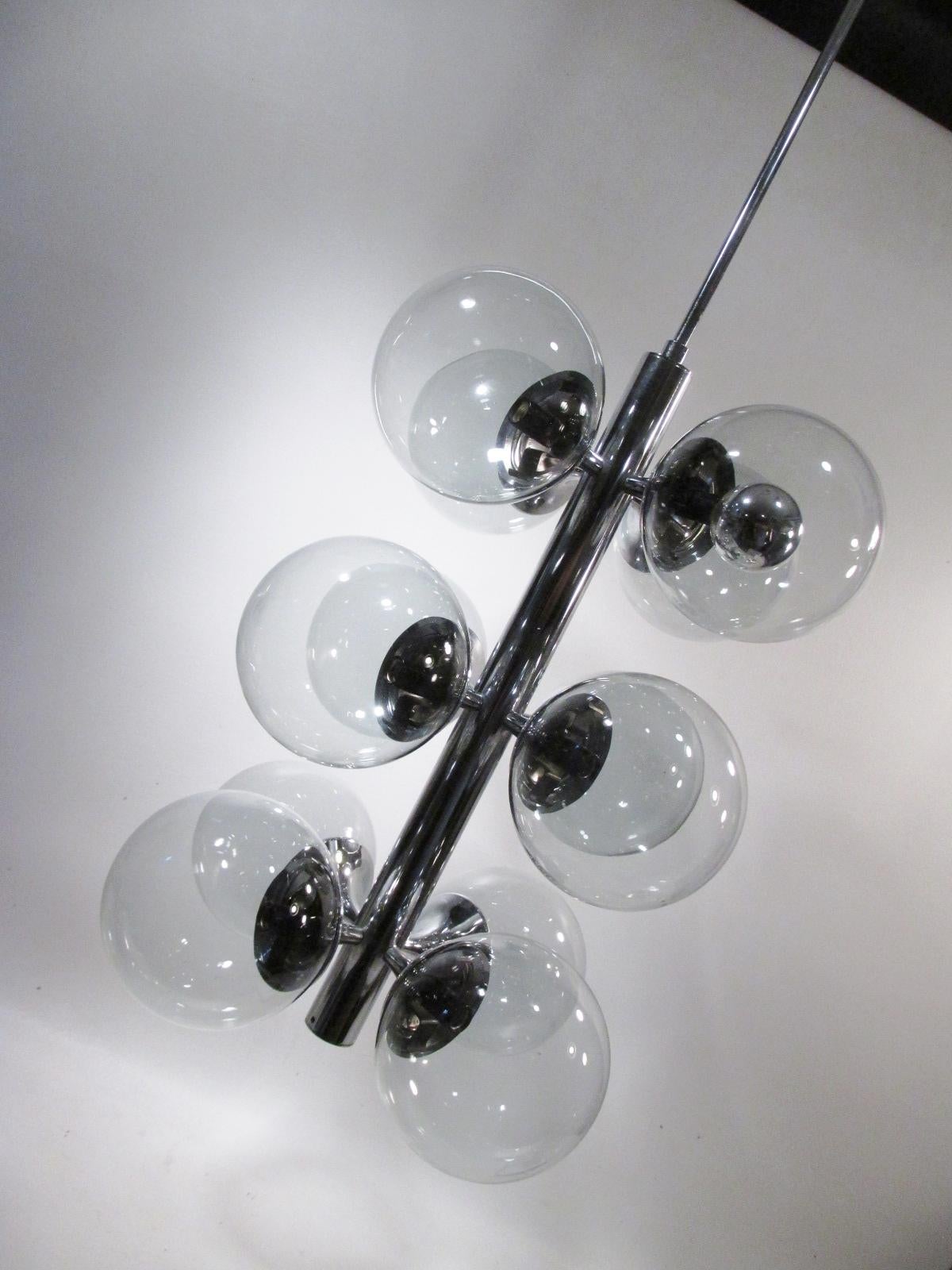 Iconic 12 light Lightolier chrome and smoke glass bubble chandelier. Chrome fixture is 31” long with 11” of original chain, a 42” total drop from ceiling. Approx widest diameter is 14” and each light smoke glass ball is approx. 5” dia. 

Condition