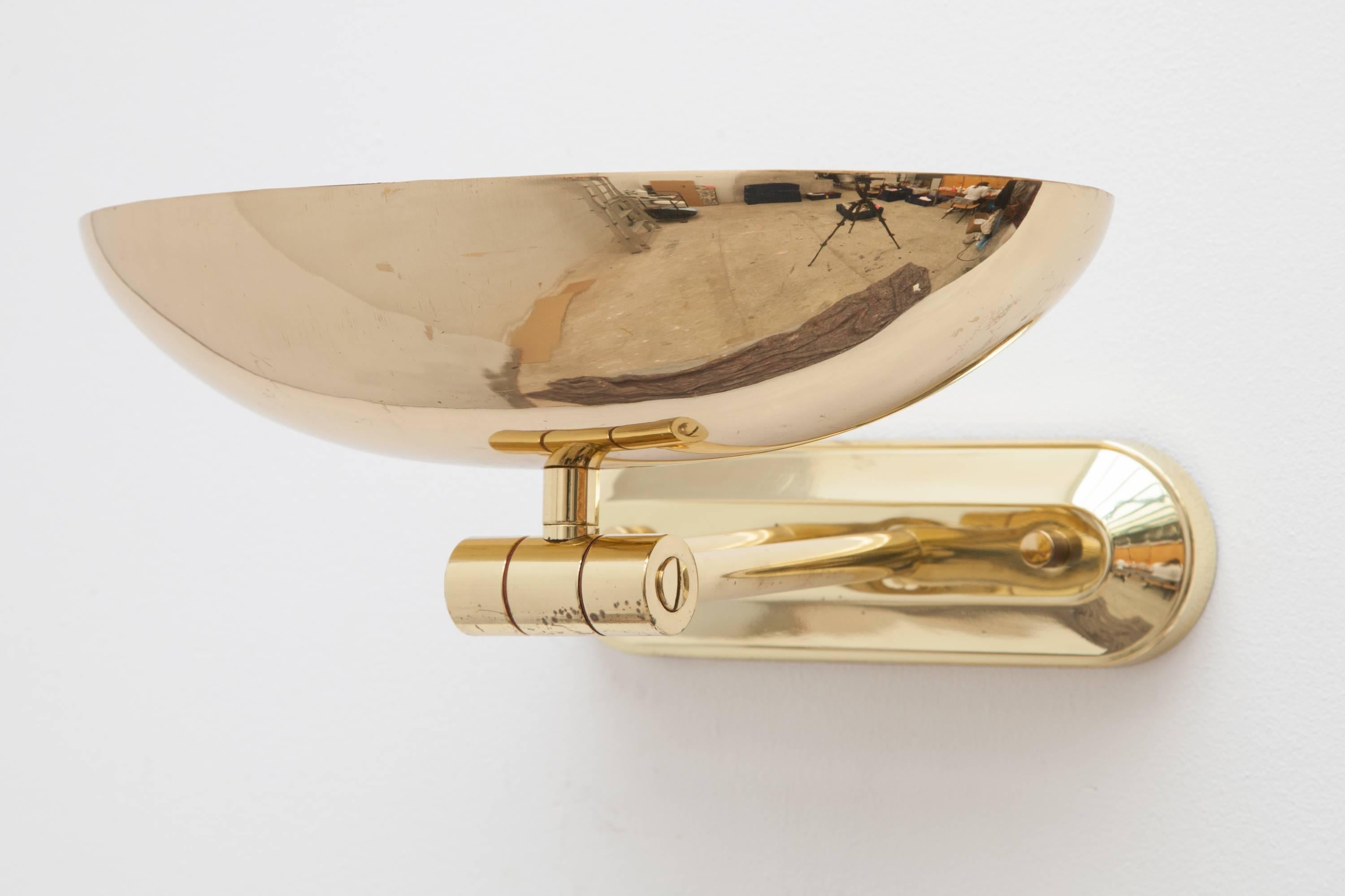 A gorgeous brass Italian wall lamp from the 1970s-1980s, oval form. Adjustable hinge allows the sconce to be tilted for perfect illumination. 
Lit by a halogen bulb.