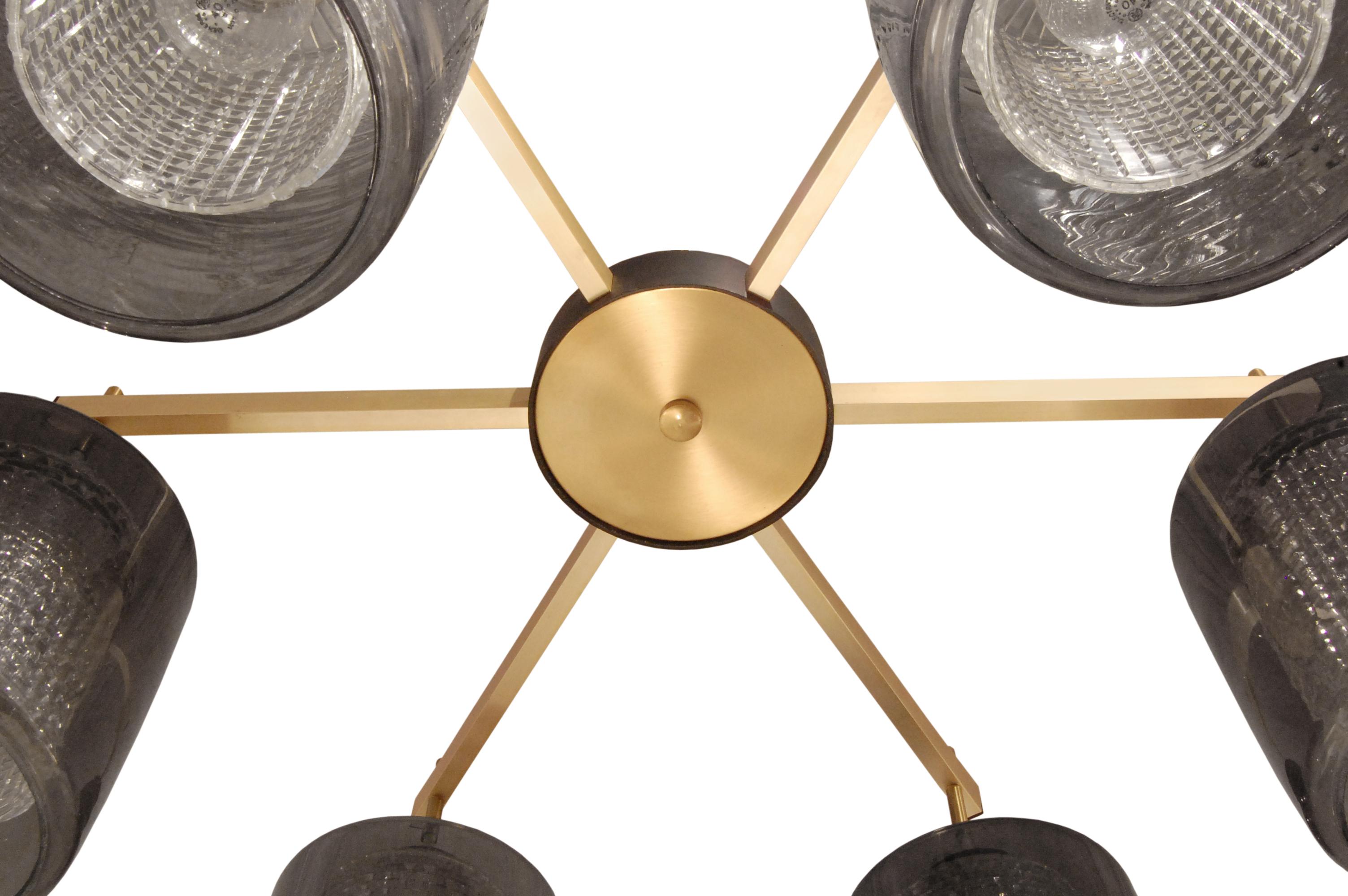 Chic chandelier with 6 arms in brushed brass with textured glass diffusers under smoked glass shades by Lightolier, American, 1950s (Lightolier label present). The combination of brushed brass and smoked glass is luxurious.
