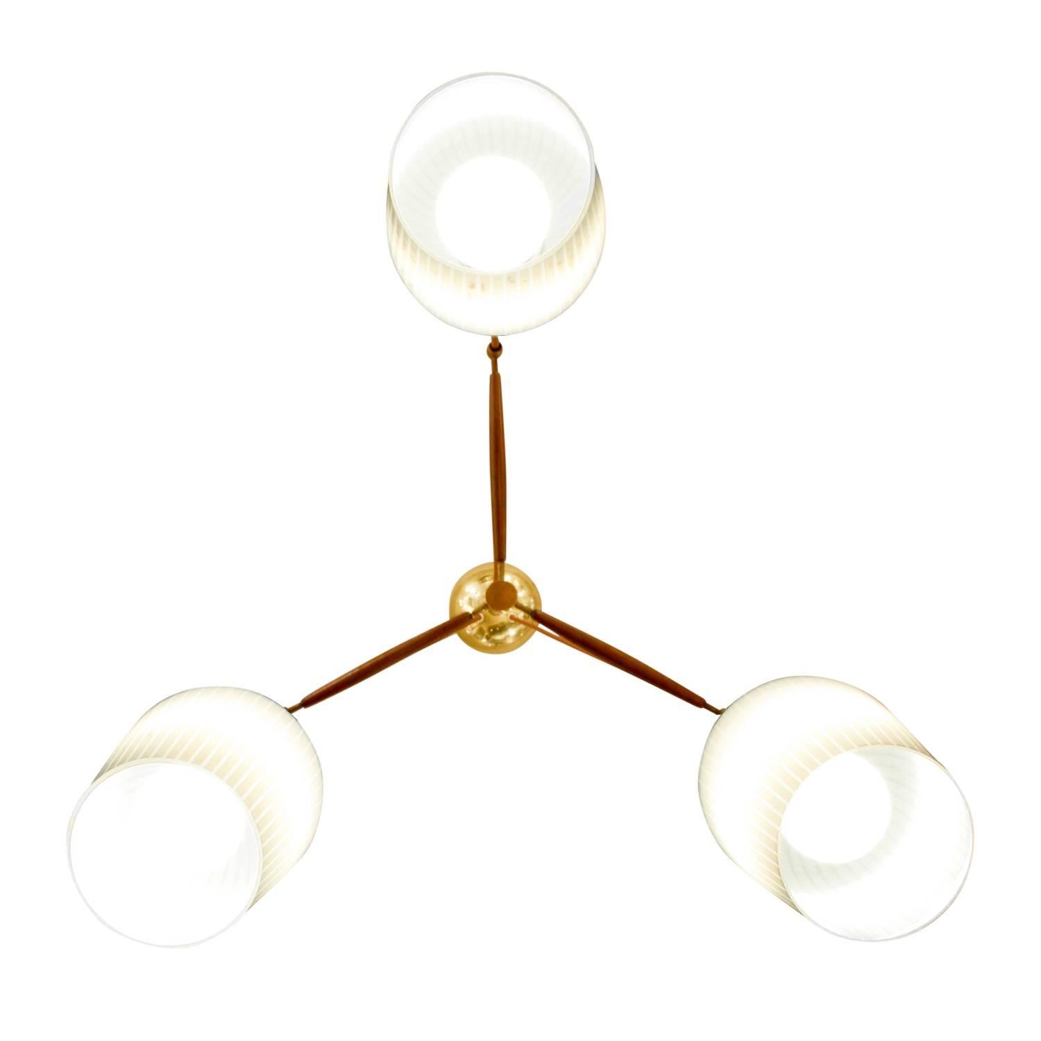 Chandelier with three hanging pin-striped milk glass shades with walnut armature and brass accents by Lightolier, American, 1950s. (Lightolier label on canopy). The drop can be modified to spec.