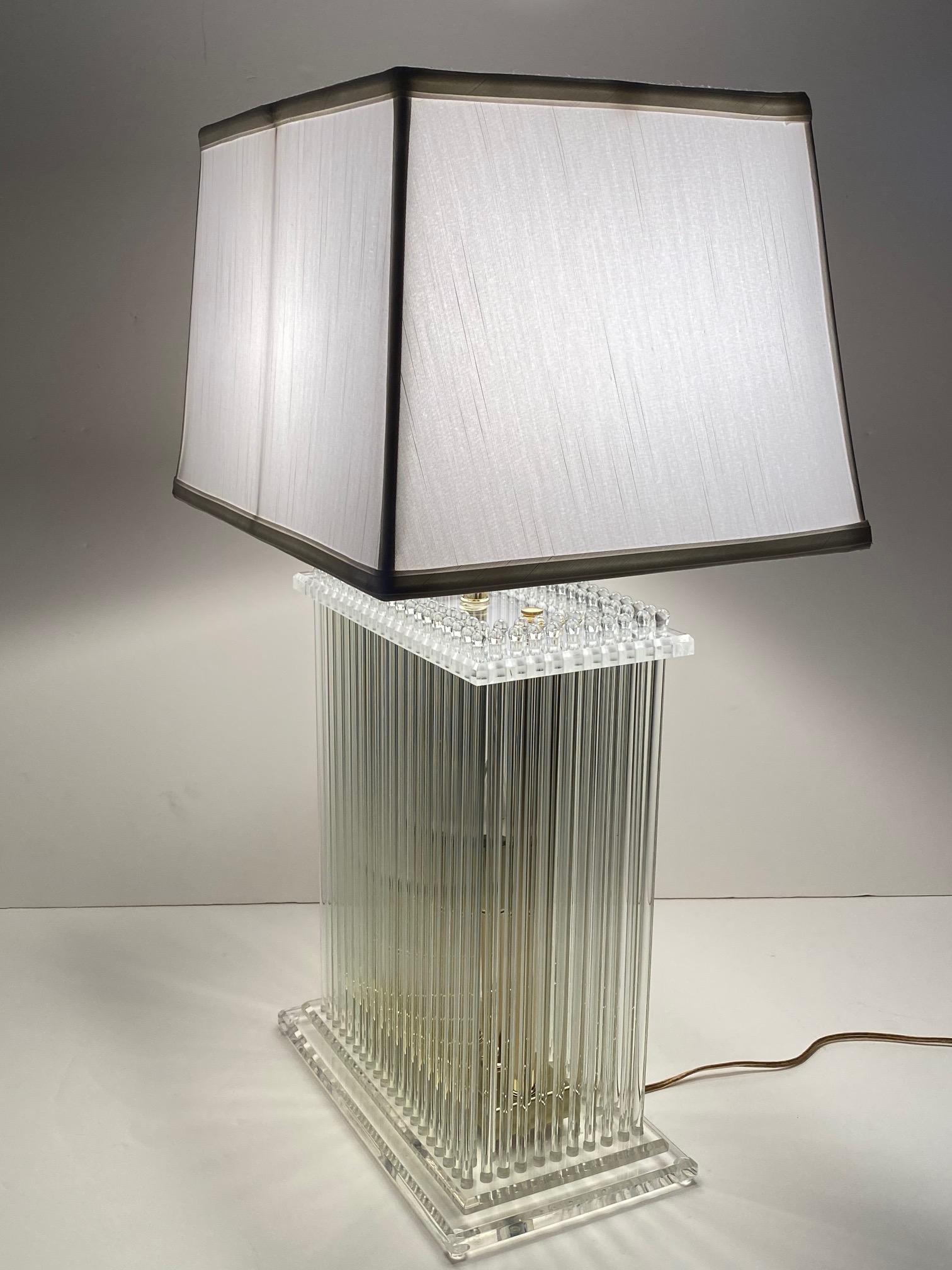 A glamorous Lucite and brass table lamp ingeniously designed with dozens of glass rods around the rectangular periphery.
Shade optional. The shade in photos is 16 W x 12 D x 10 H.