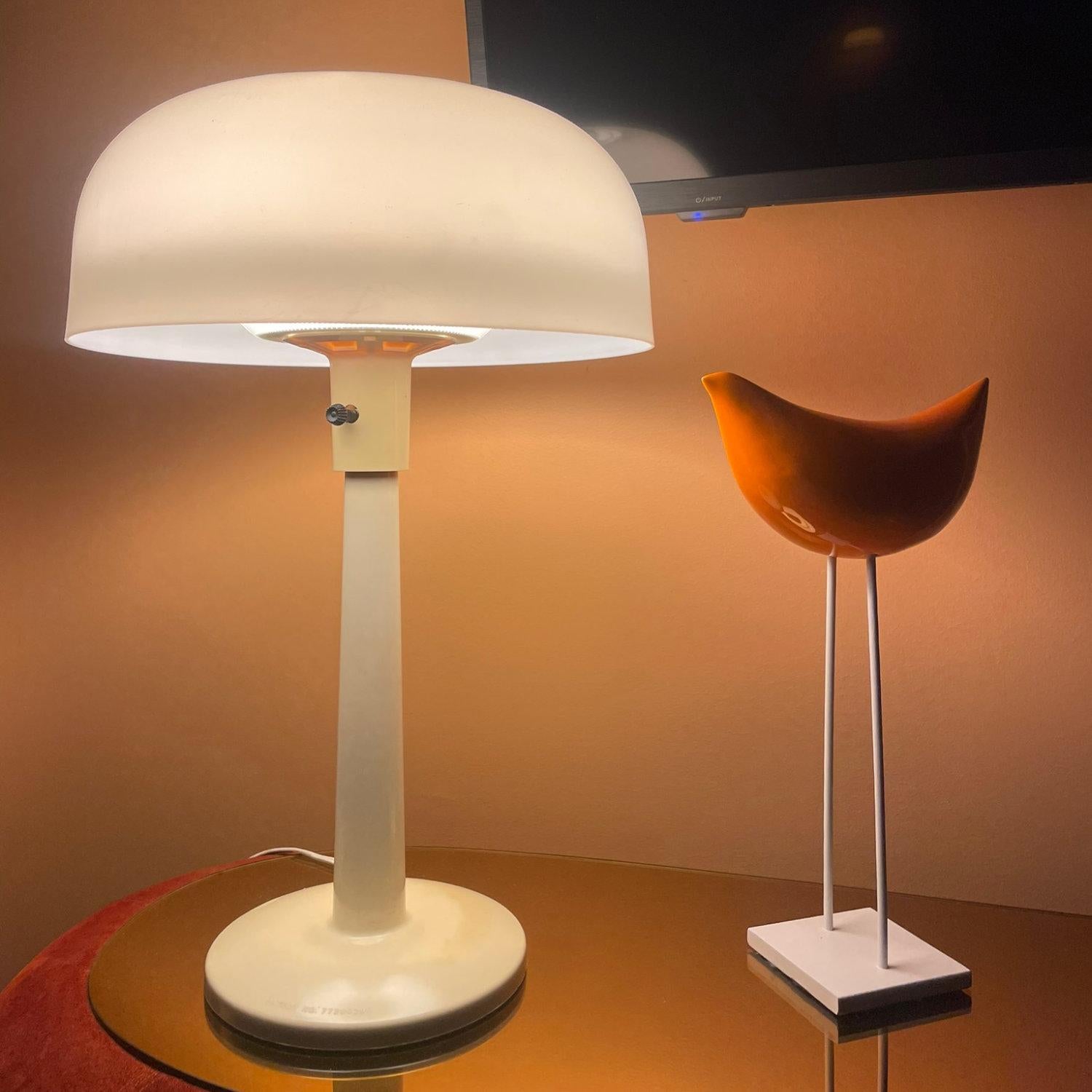 Vintage Lightolier white mushroom table lamp. Designed by Gerald Thurston. The 20th Century Modern lamp gives a off a beautiful ambient light as it diffuses through the mushroom shaped top. The lamp and shade are original. Both the lamp and shade