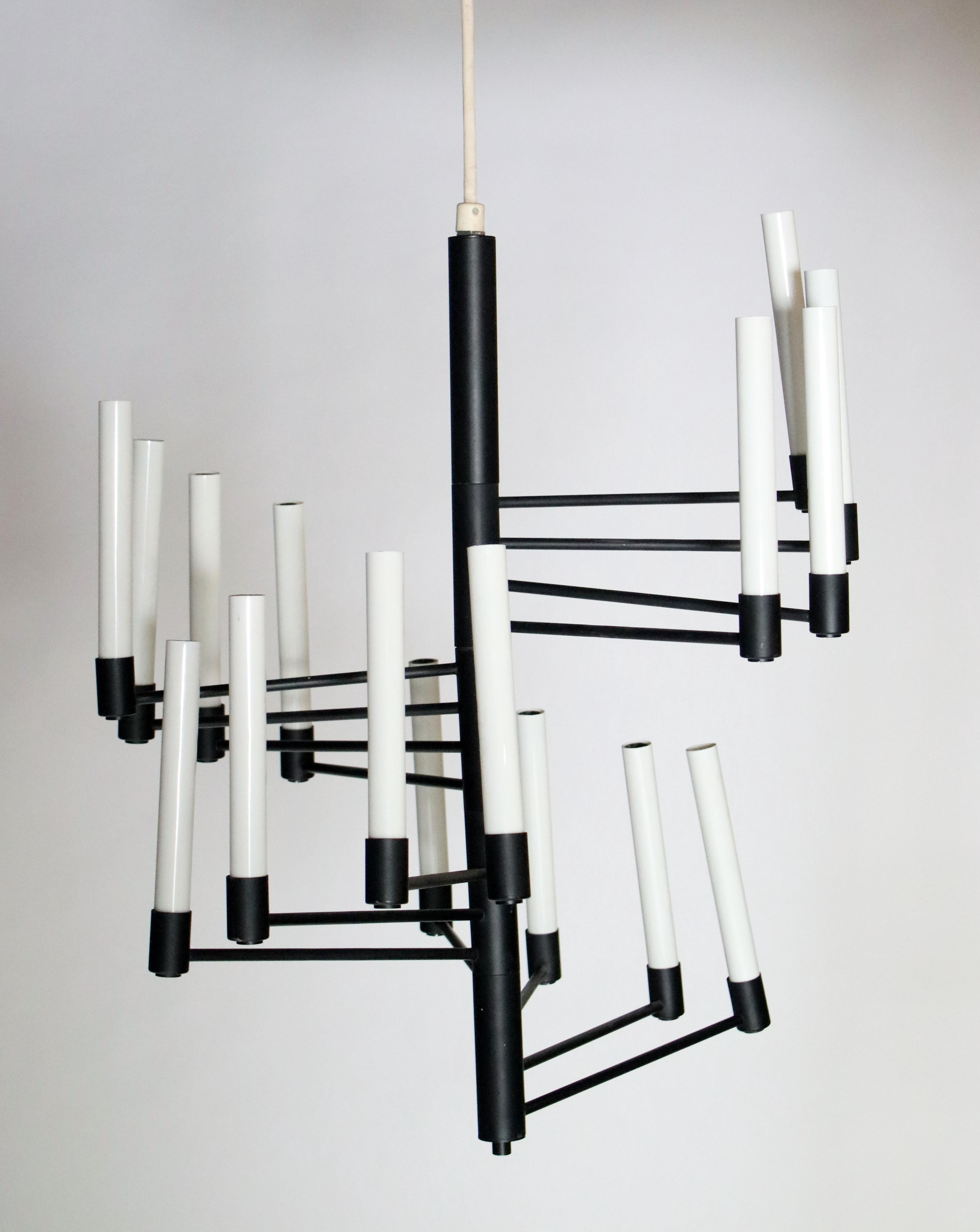 Black metal with white candles chandelier features 16 adjustable lights. Labelled 