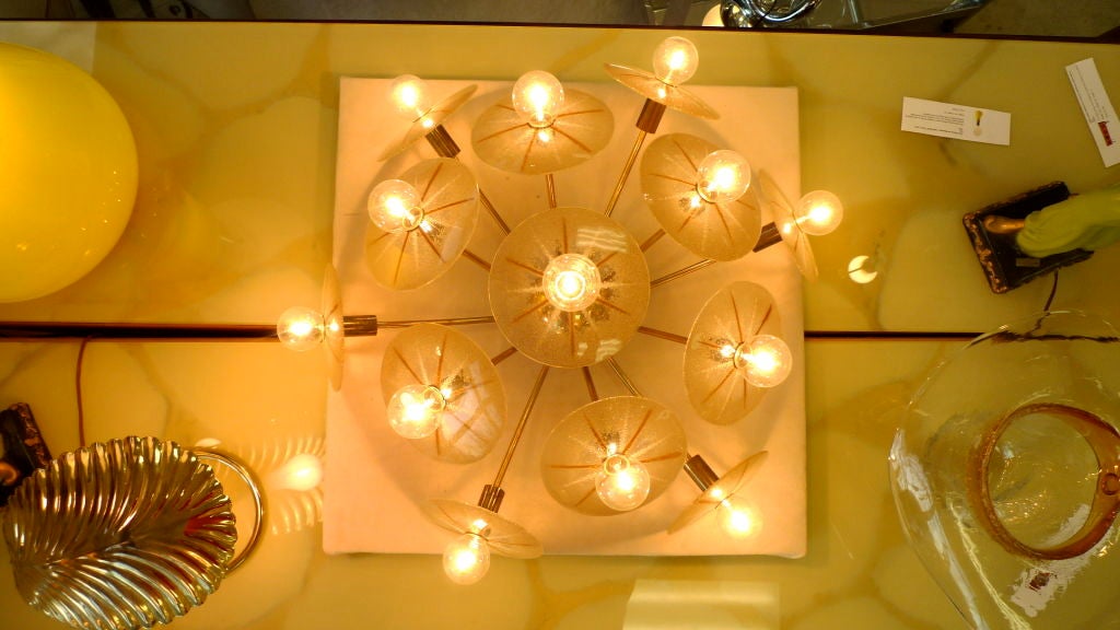 From Lightolier's Claremont Collection circa 1953 (see image 20) we present this show stopping domed shaped ceiling fixture with 13 curved brass sputnik arms and cones for candelabra sockets, each of which has a fitting to secure a concave orange