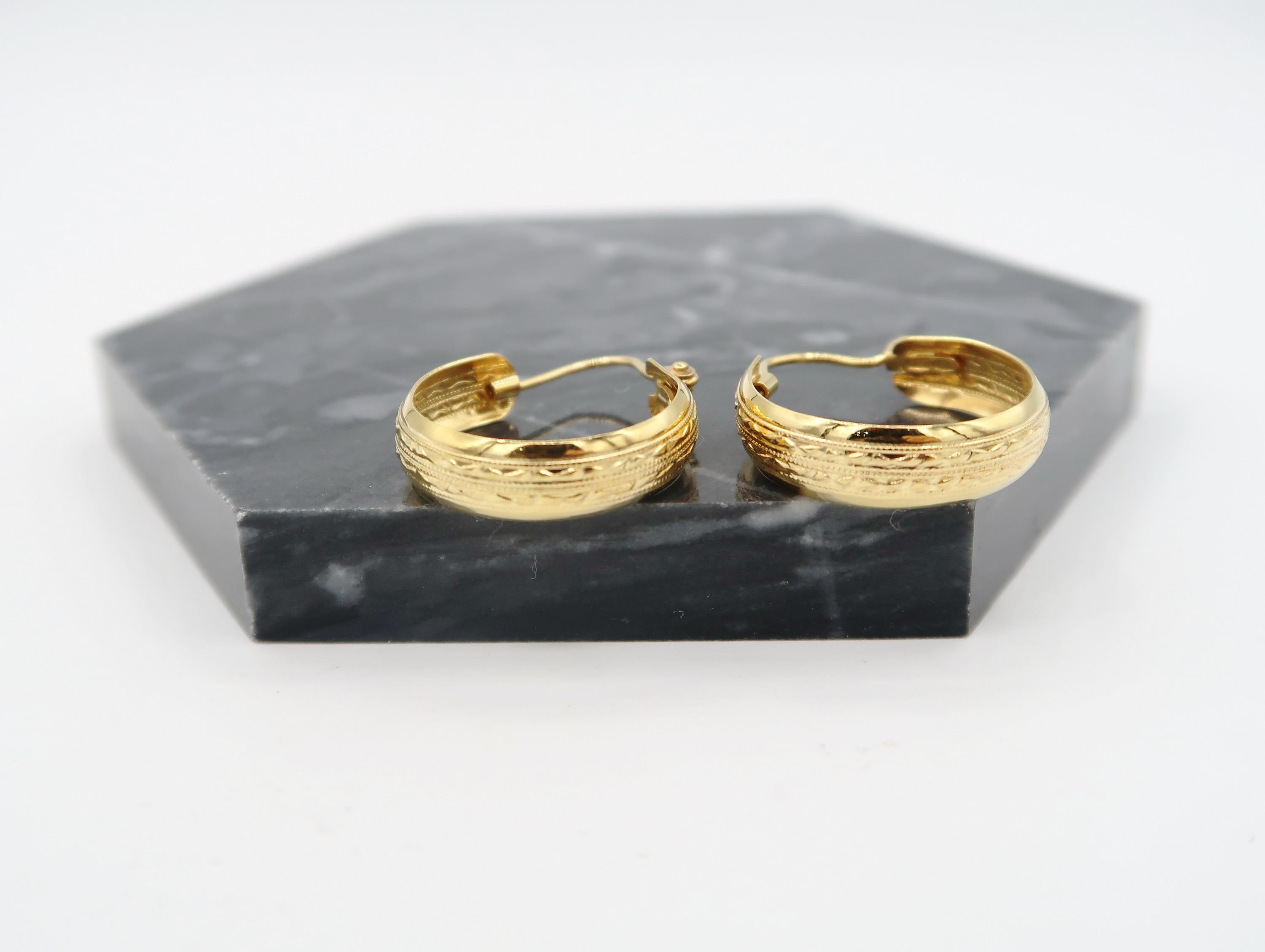 Leichte, breite, geschnitzte Streifen mit Riegeln aus 18K Gelbgold Reifenohrringe

Gold: 18K Gelbgold, 3,87 g

Breite: 6 mm
Länge: 27 mm