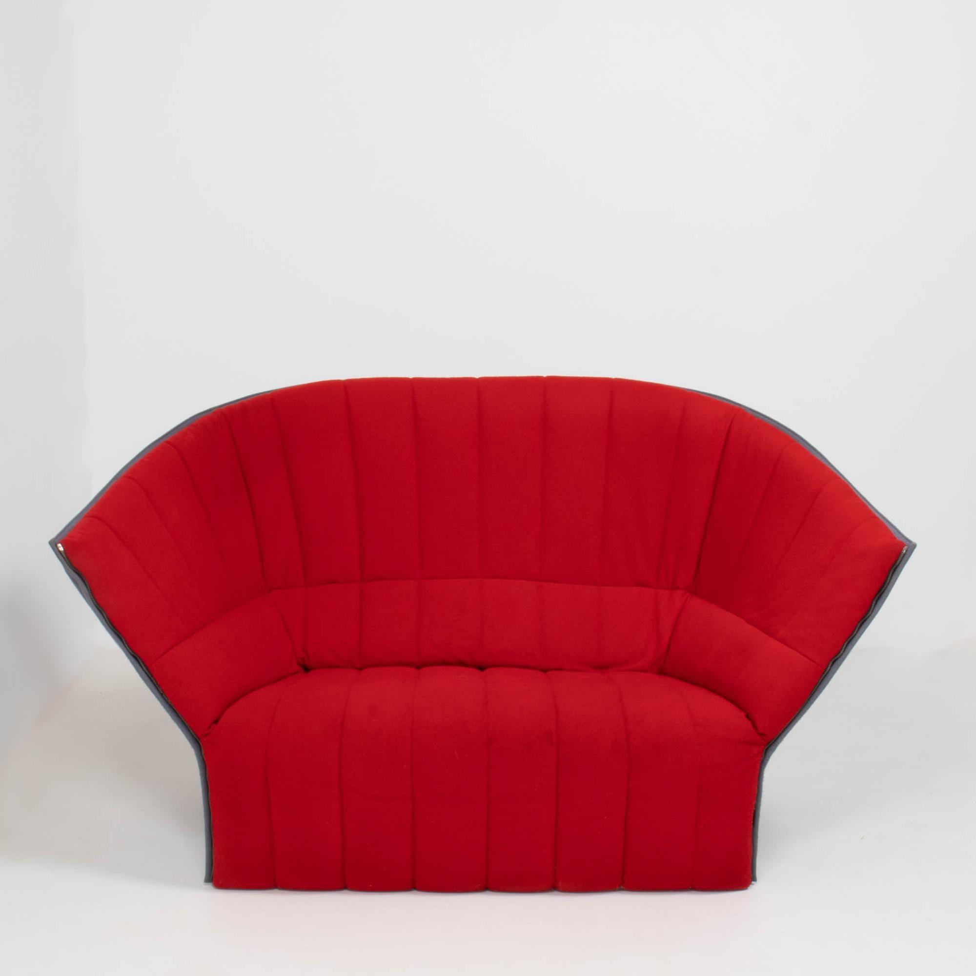 Designed by Inga Sempé for Ligne Roset, the Moel loveseat is a striking piece of contemporary design.

With a shell-like silhouette, the Moel loveseat sofa features a quilted seat front in bright red fabric and a contrasting grey fabric