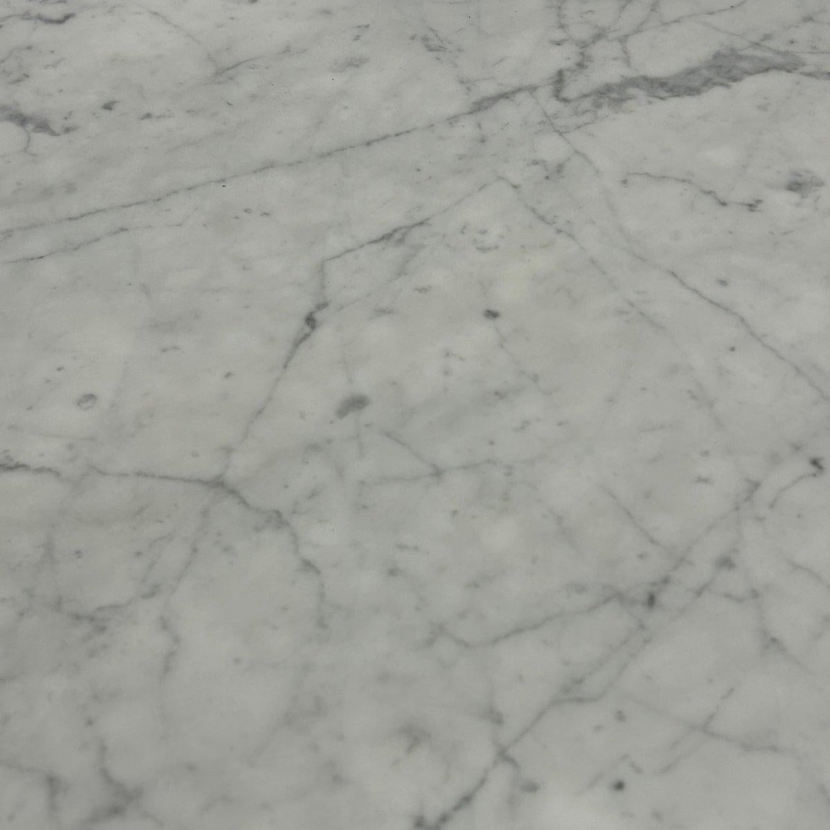 Introducing the Ennea Marble Dining Table by Ligne Roset, a stunning addition to any dining room. Crafted with precision and elegance, this table features a sleek ceramic top supported by a unique geometric base. The marble effect of the top adds a