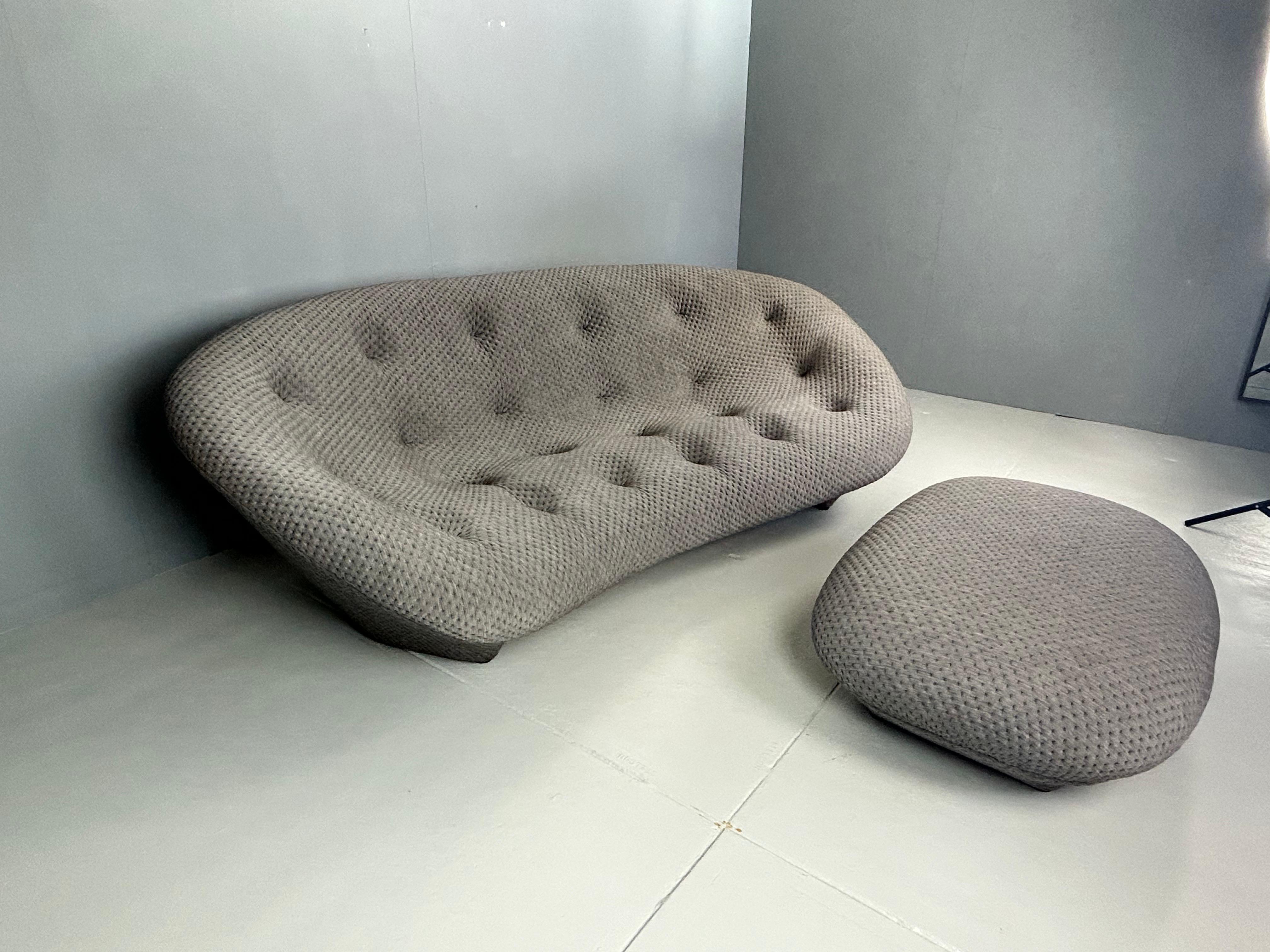 Introducing the Ligne Roset Ploum Sofa, a luxurious addition to any living space. This unique sofa features a plush, curved design that provides ultimate comfort and support. The sleek, modern lines and soft, textured fabric create a sophisticated
