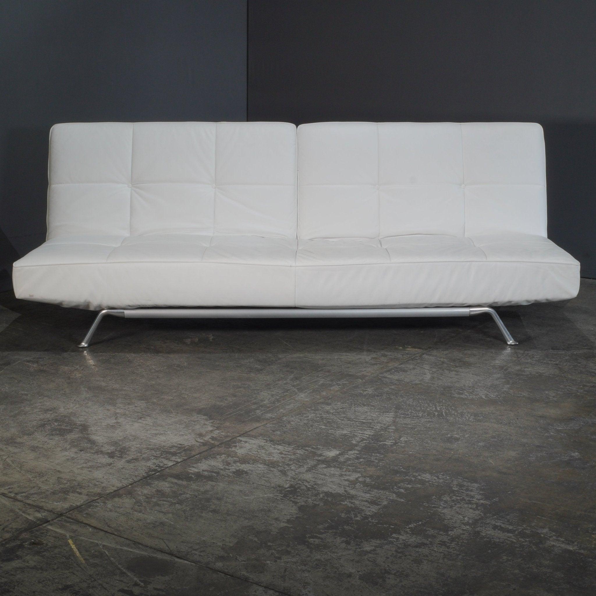The Ligne Roset Leather Smala Sofa, designed by Pascal Mourgue, epitomizes modern elegance and comfort. Upholstered in luxurious cream faux leather, its sleek lines and minimalist aesthetic create a stunning focal point in any living space. The