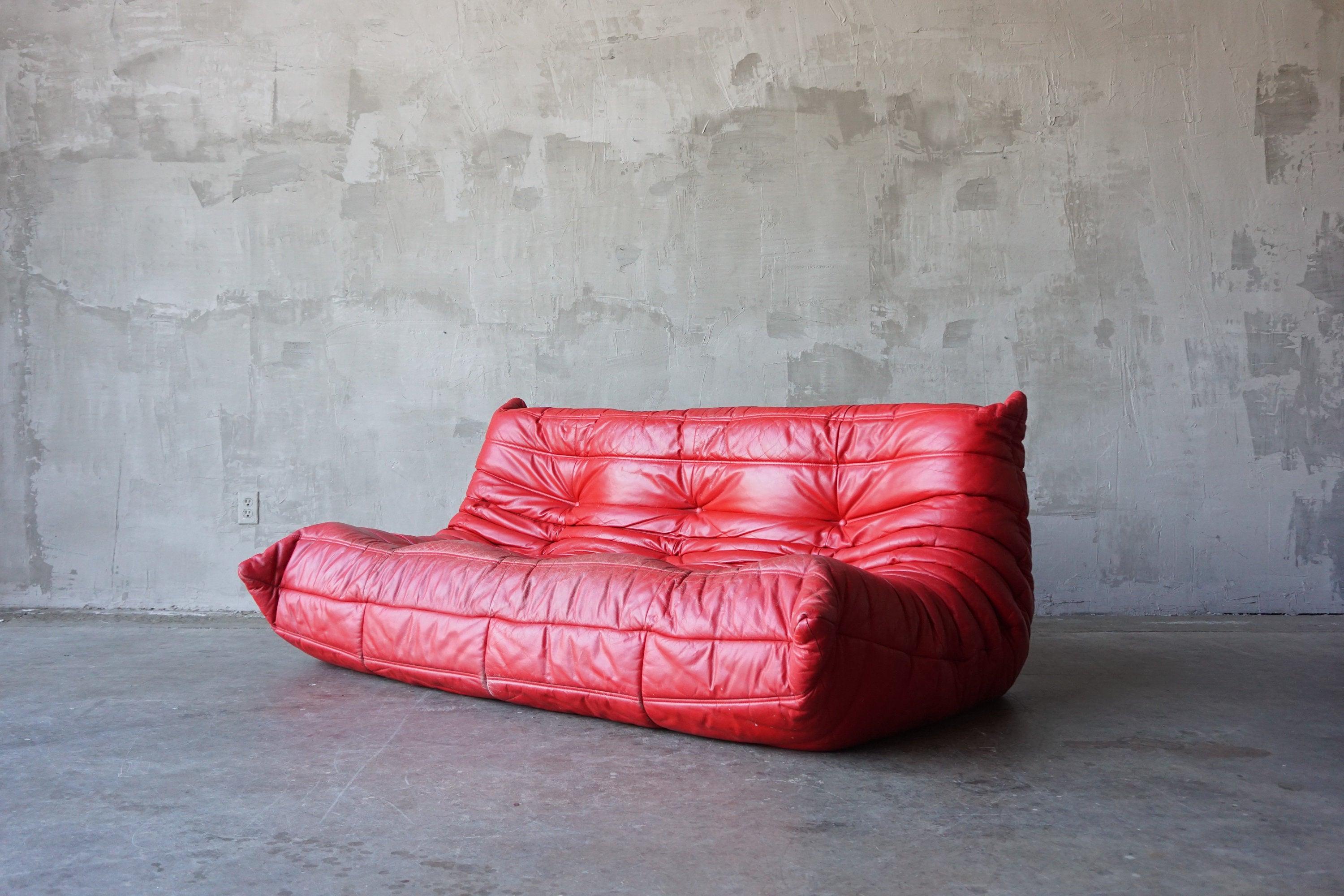 Stunning vintage ‘Togo’ sofa in lipstick red leather designed by Michel Ducaroy for Ligne Roset, circa 1970s. 

This piece has an amazing developed patina that can only be acquired with time. 

Measures 72” W x 42” D x 29” H. 
Seats measure 12”
