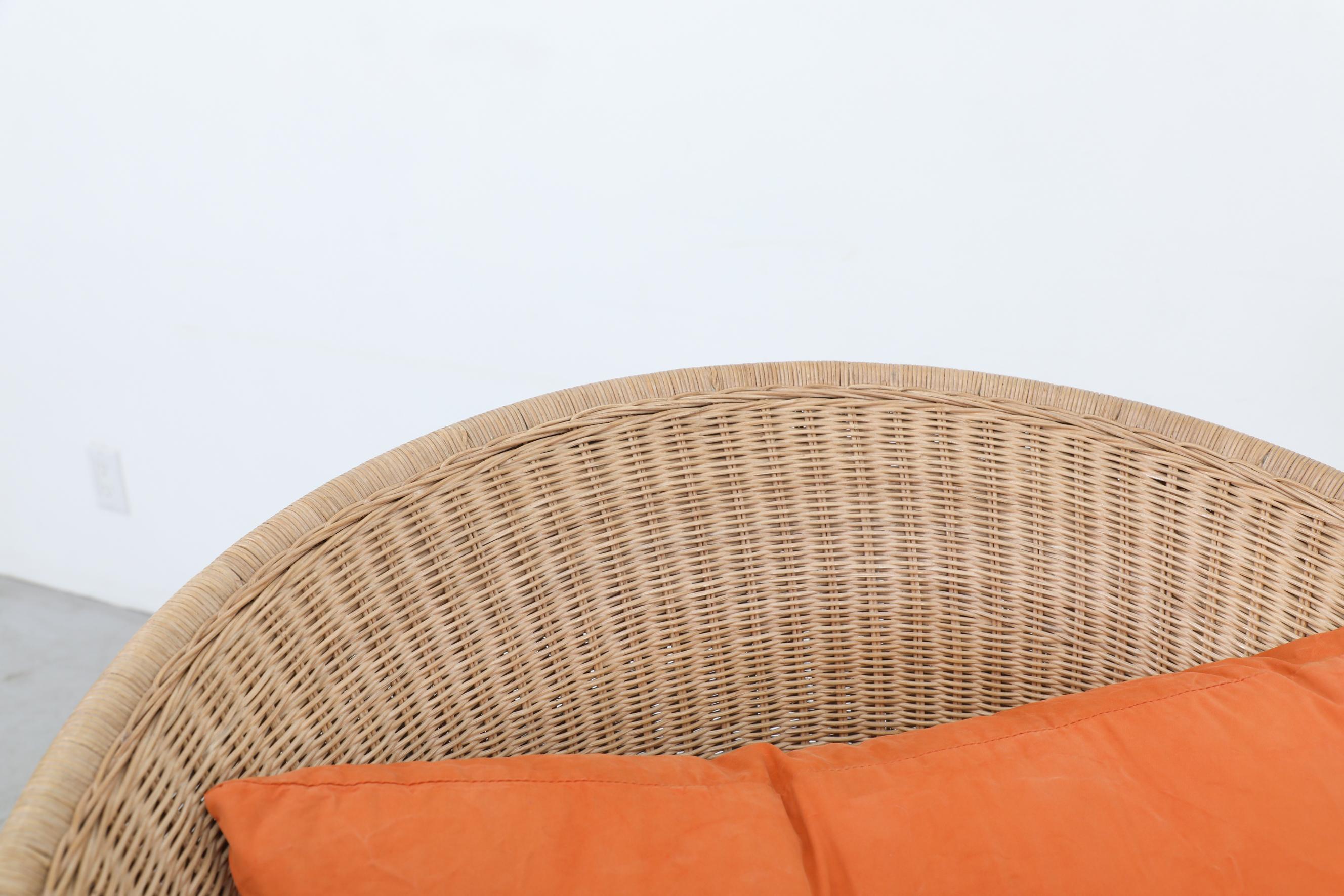 Ligne Roset Organisch geformter Rattan-Loungesessel mit orangefarbenen Kissen und Metallfüßen im Angebot 5