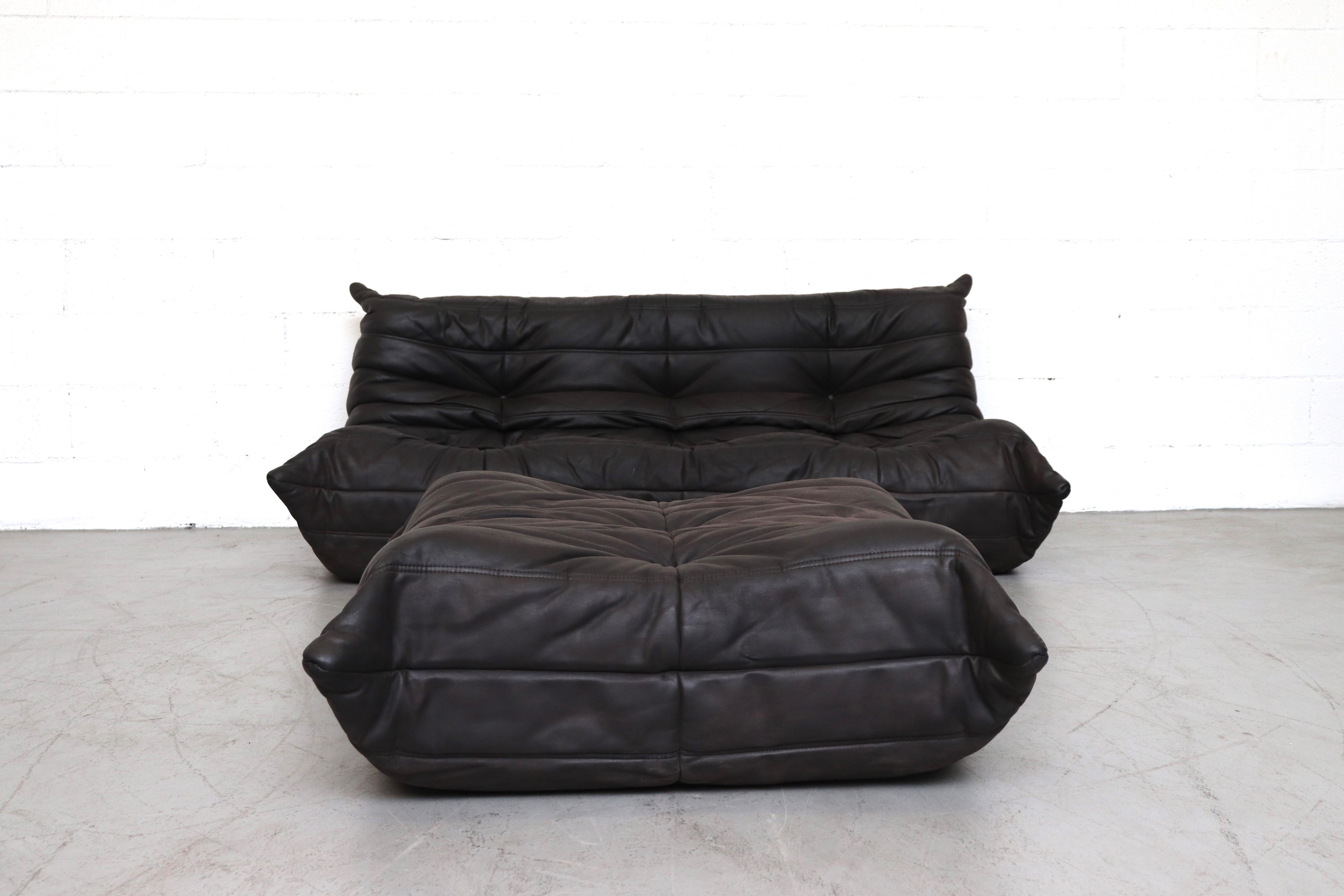 Ligne Roset 'TOGO' Matte Black Leather 3 Seater Sofa with Matching Ottoman. Designed by Michel Ducaroy. In Original Condition with Visible Wear and Patina. Another Similar Loveseat is available and listed separately.

Ottoman measures: 36 x 30.5 x