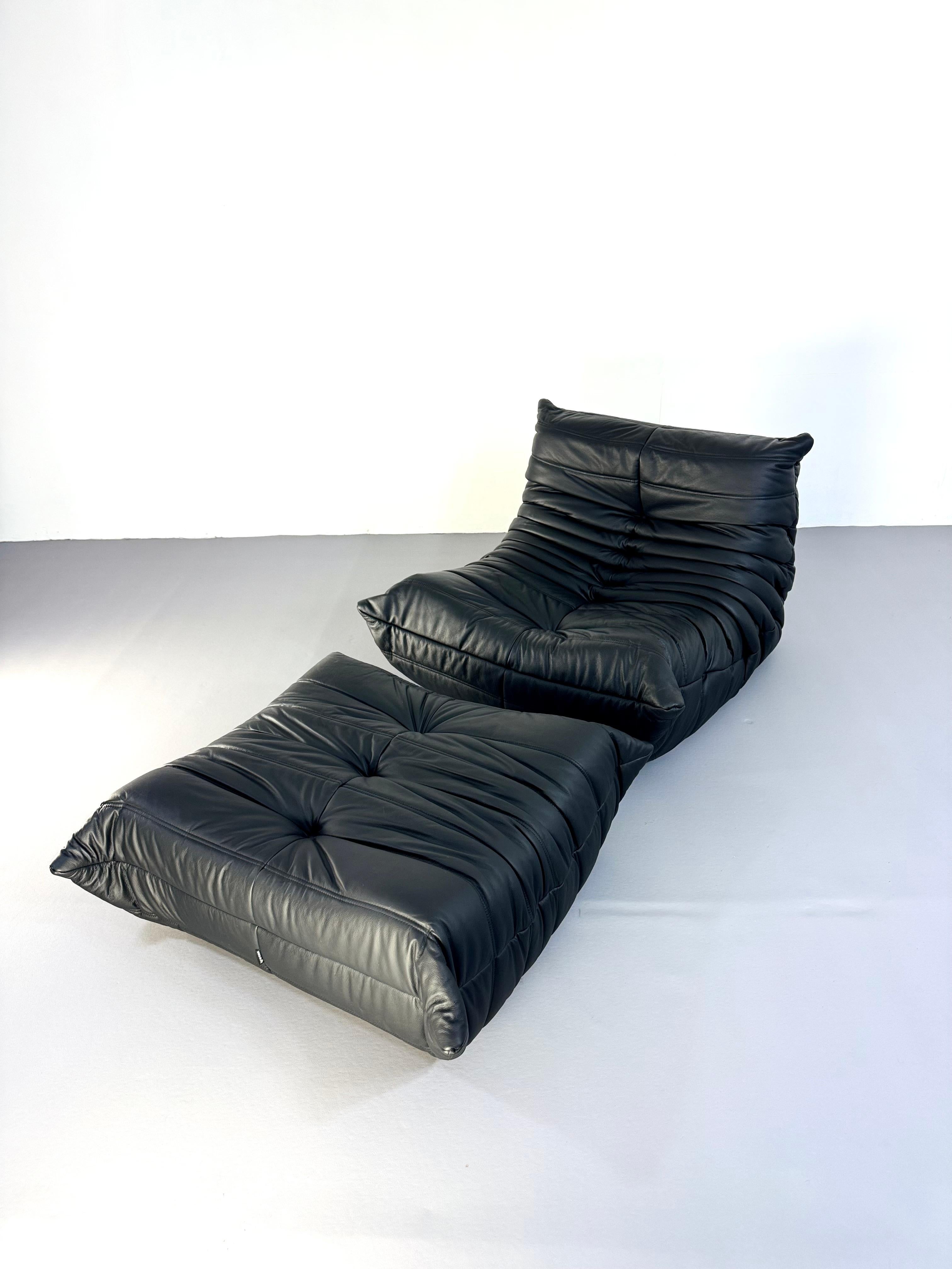 Dieses atemberaubende Set von Ligne Roset Togo, bestehend aus einem 1-Sitzer-Sessel und einem passenden Hocker, verkörpert das ikonische Design von Michel Ducaroy, das erstmals 1973 vorgestellt wurde. Mit luxuriösem schwarzem Leder gepolstert,