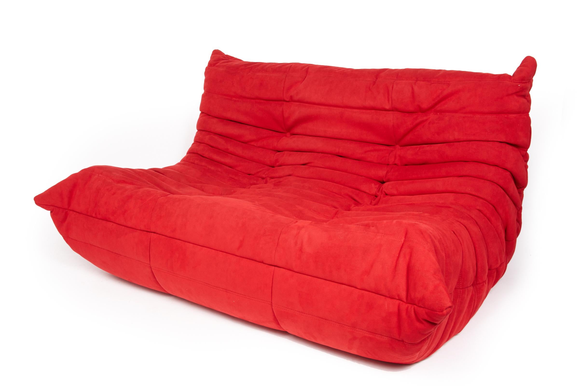 Ensemble de salon Togo 3 pièces tendance par Ligne Roset. Fabriqué en France et vendu par Roche Bobois. Profil bas et super confortable, il est recouvert de faux daim rouge facile d'entretien. Le bas de la fermeture à glissière est en coutil bleu et