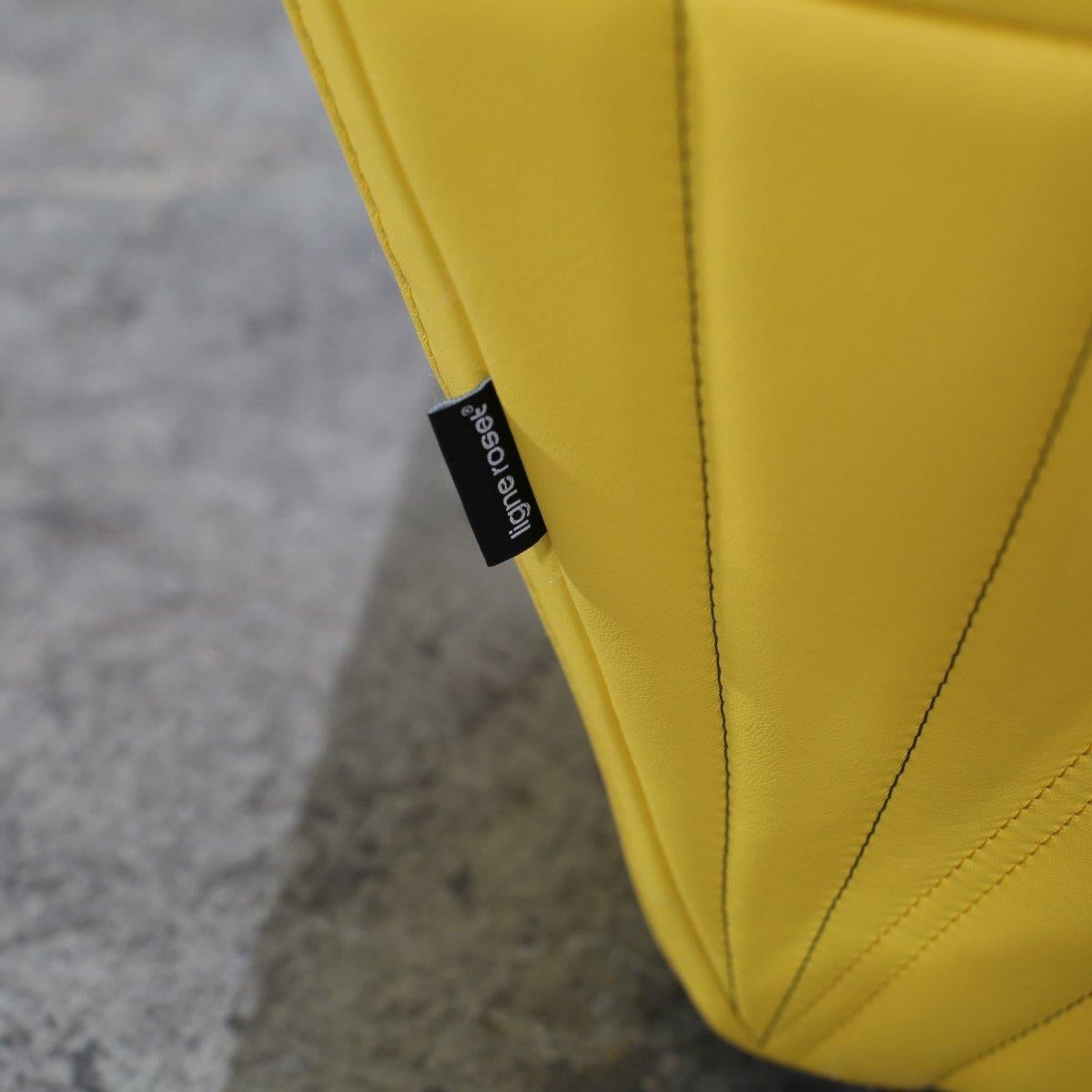 Introducing the Ligne Roset Yellow Facett Armchair, designed by renowned duo R. & E. Bouroullec. This stunning piece is a true statement of luxury and style, featuring a unique faceted design and a vibrant yellow color that would add a pop of colour