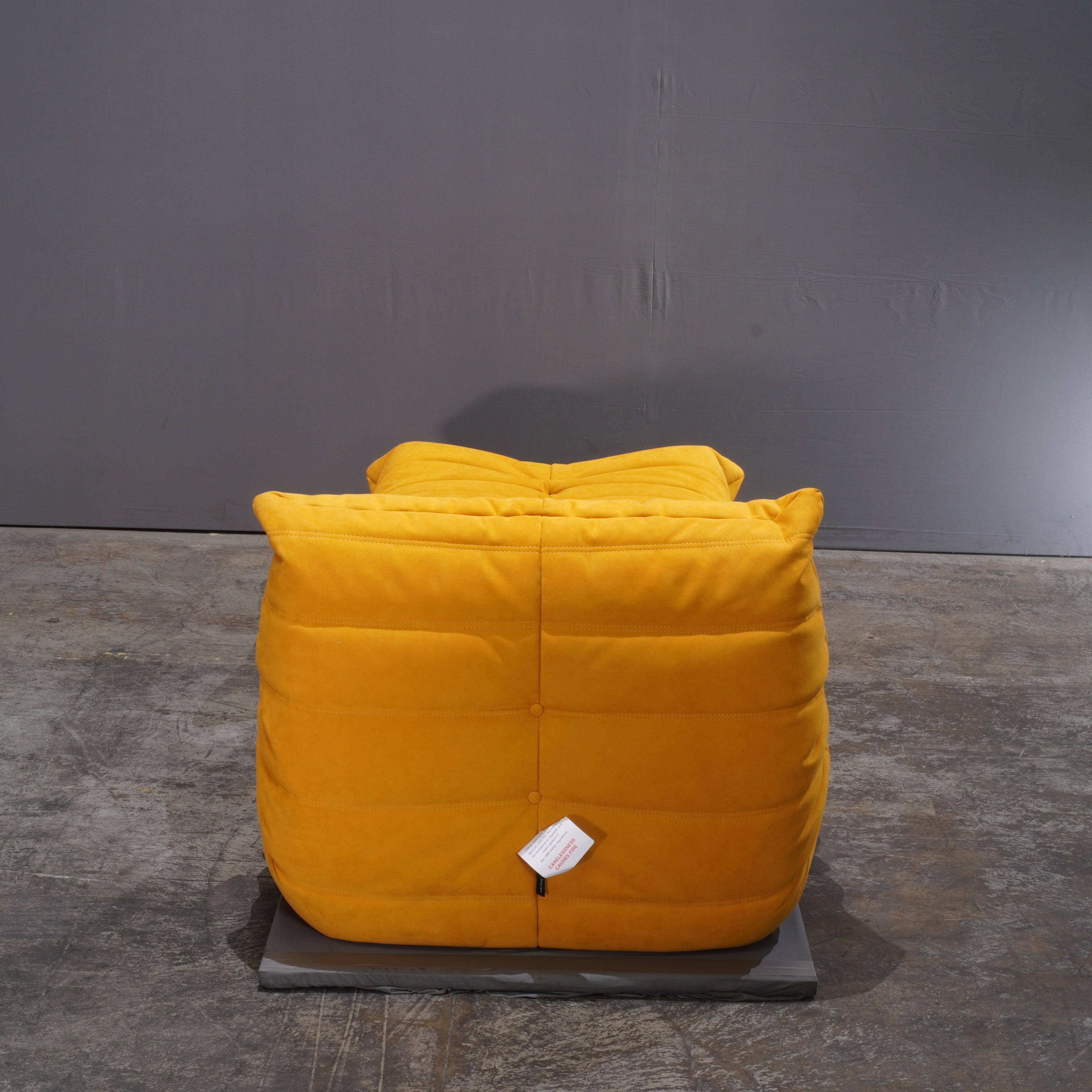 The Togo Armchair is an iconic design by Ligne Roset. This armchair has been reupholstered in high-quality yellow fabric. Made completely from foam, with three different densities, this sofa range was built for comfort.  It features the instantly