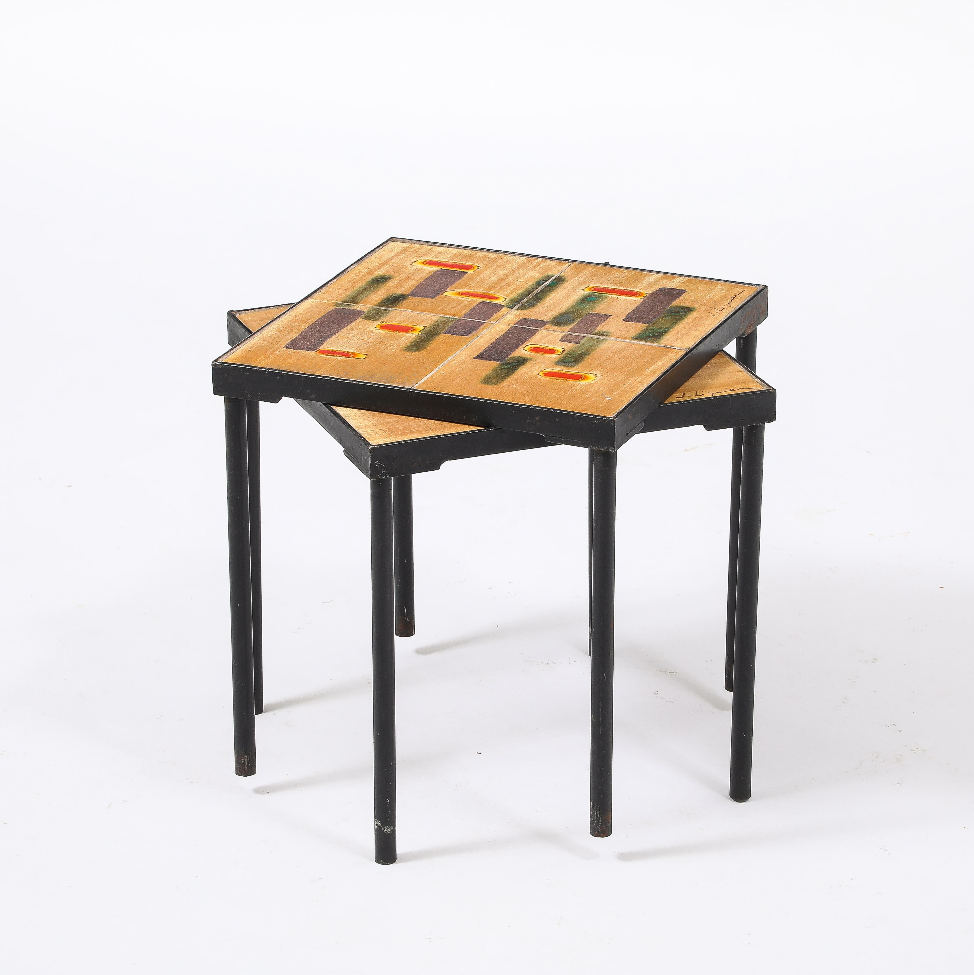 Coppia di tavoli in ferro battuto con piano astratto in ceramica.
