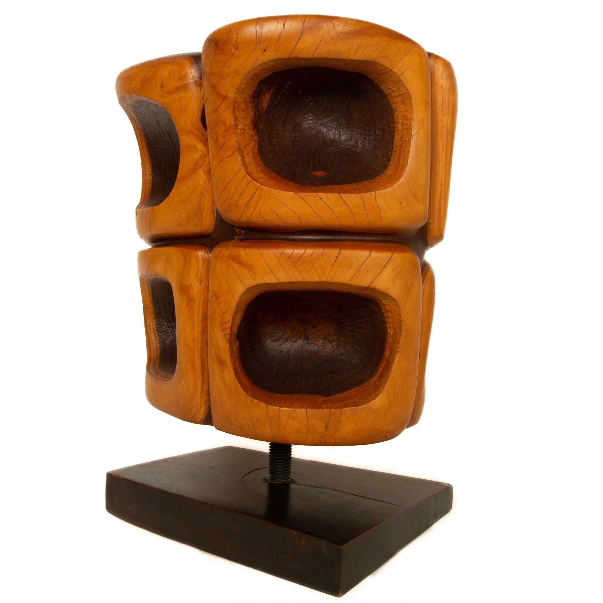 Une sculpture unique, taillée à la main dans du bois de fer massif (lignum-vitae), montée sur un socle en bois en forme de coin par l'intermédiaire d'une tige filetée. La sculpture est formée d'une seule grande section de lignum-vitae, l'anneau