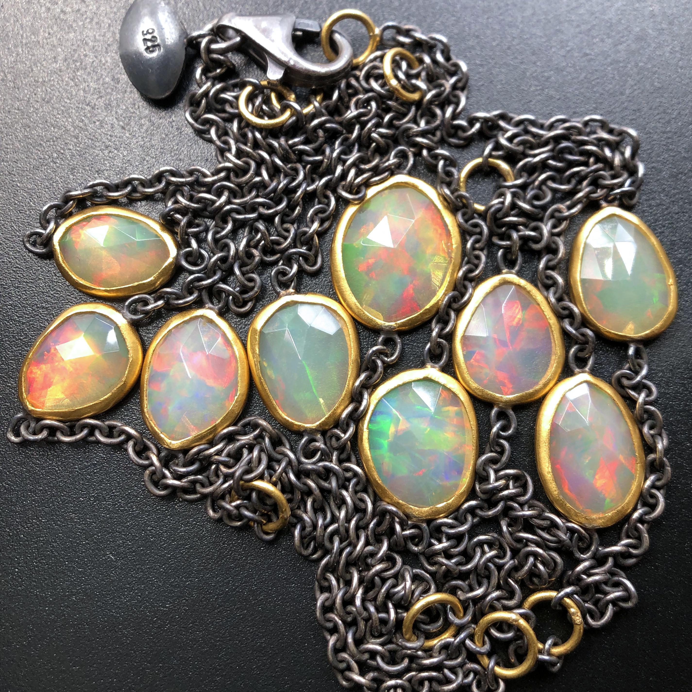 Long Necklace handcrafted by acclaimed jewelry artist Lika Behar featuring nine matched, faceted Ethiopian opals (12.74 total carats) with spectacular color and fire, individually bezel-set in 24k gold and attached to an oxidized sterling silver