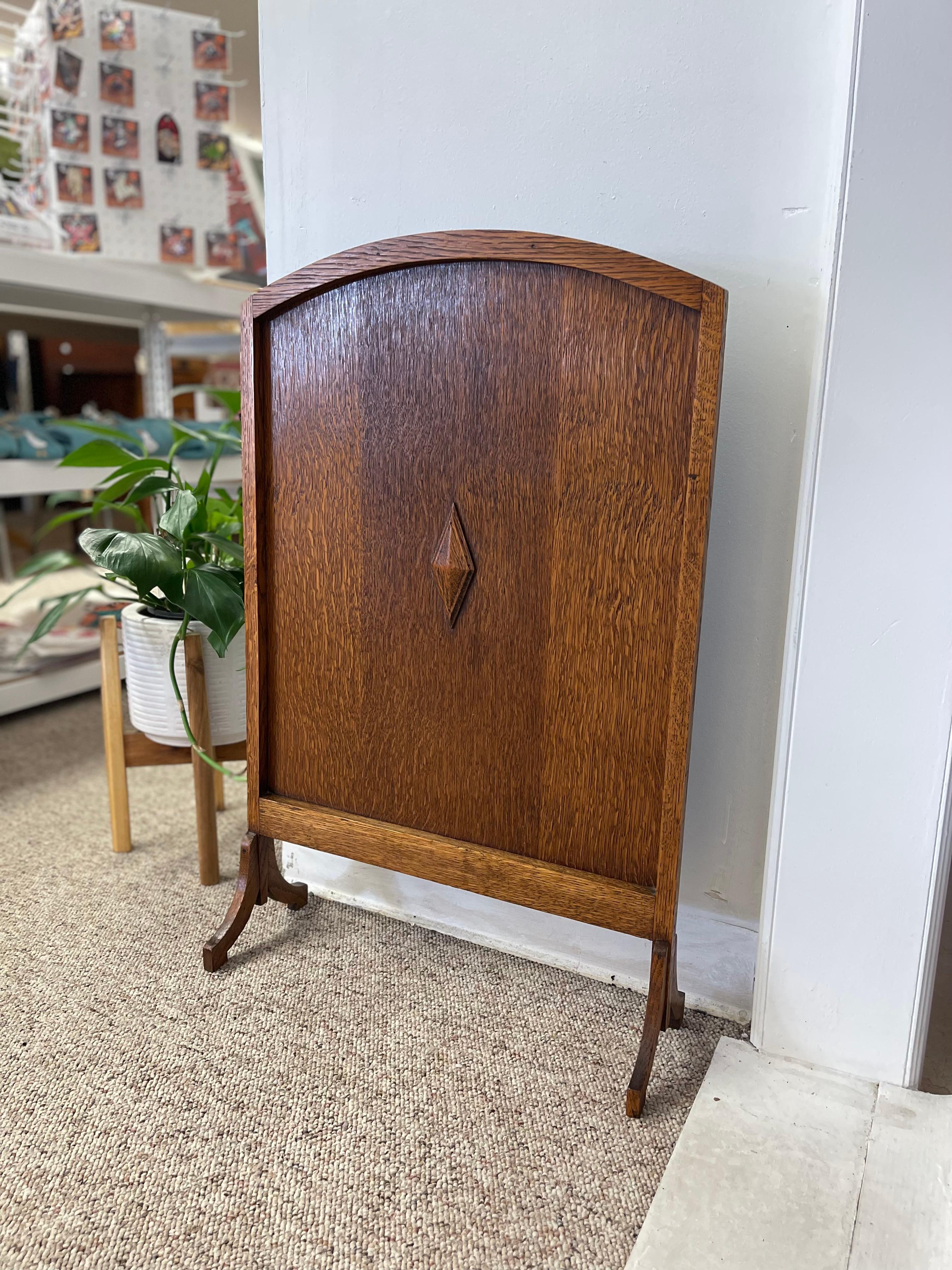  An elegant and finely crafted possibly oak fire screen from the Arts and Crafts period, likely dating to the early 20th century, circa 1910s. This piece is constructed from solid quarter-sawn oak, prized for its prominent medullary ray pattern and