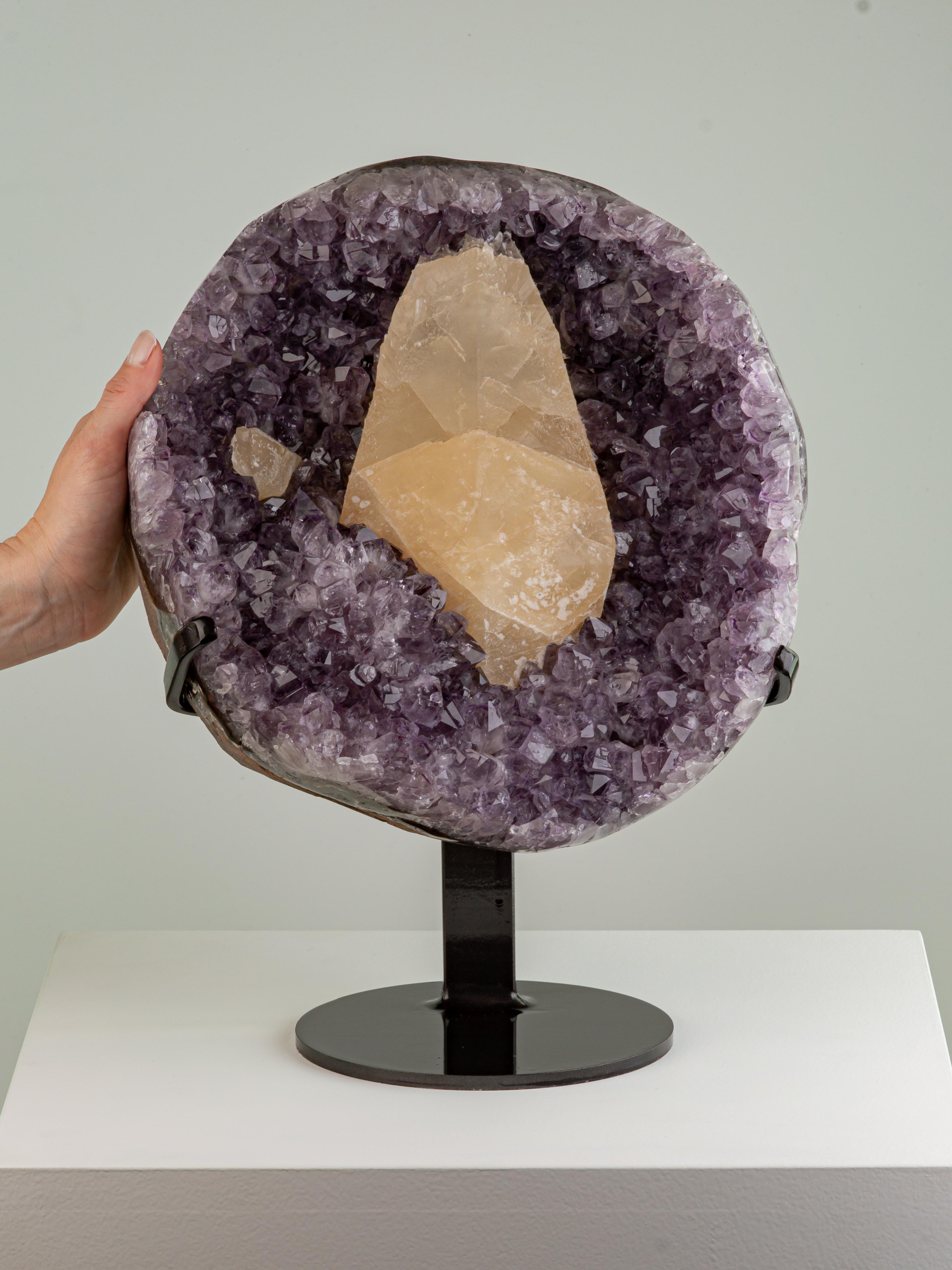 A pleasing lilac amethyst formation of large crystals with a large honey
coloured calcite at the centre and a smaller calcite to the side.

Amethyst is predominantly light violet to deep purple, but can be found with secondary hues of red and