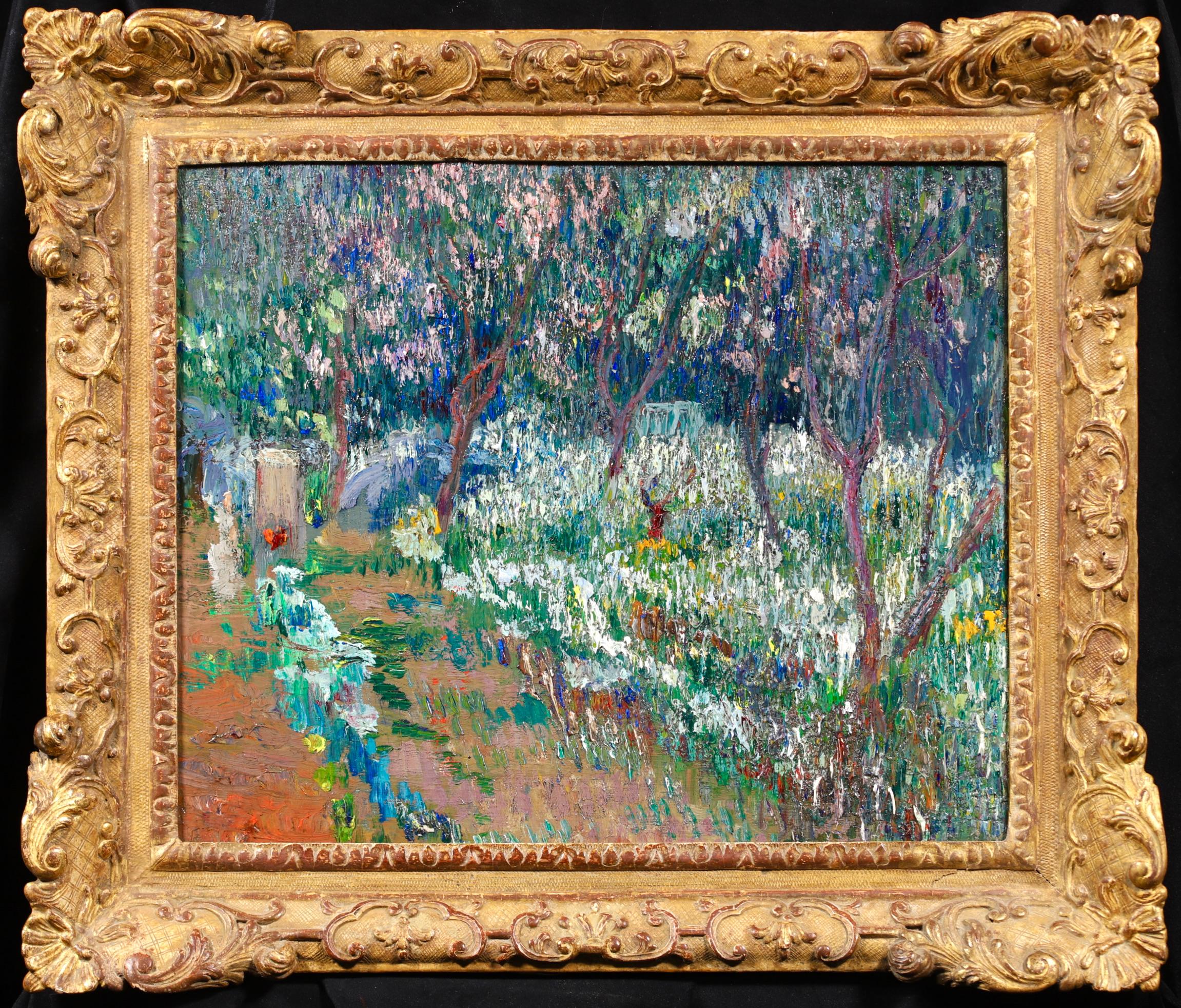 A stunning divisionist style landscape oil on canvas by American impressionist painter Lilla Cabot Perry. The work depicts a beautiful garden in Giverny in bloom. The trees are covered in pink blossom and white, blue and yellow flowers blanket the