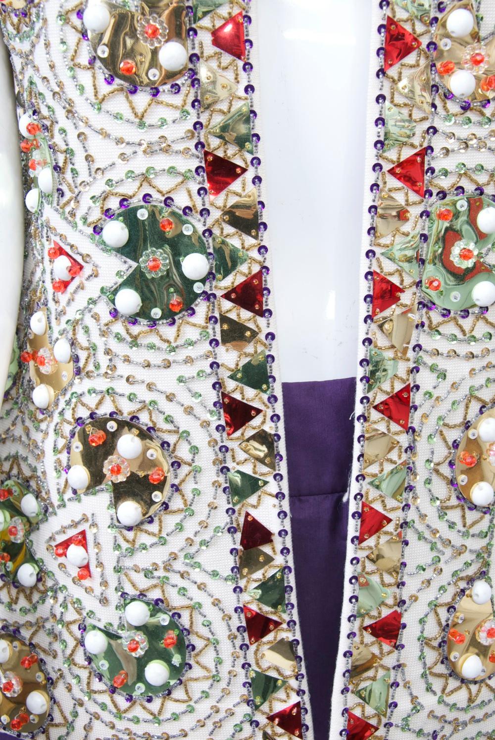 A unique piece from renowned coat and suit manufacturer Lilli Ann, this vest is extravagantly and boldly decorated with large multicolored paillettes in geometric shapes that echo the overall geometric pattern of the piece. The geometric pattern of
