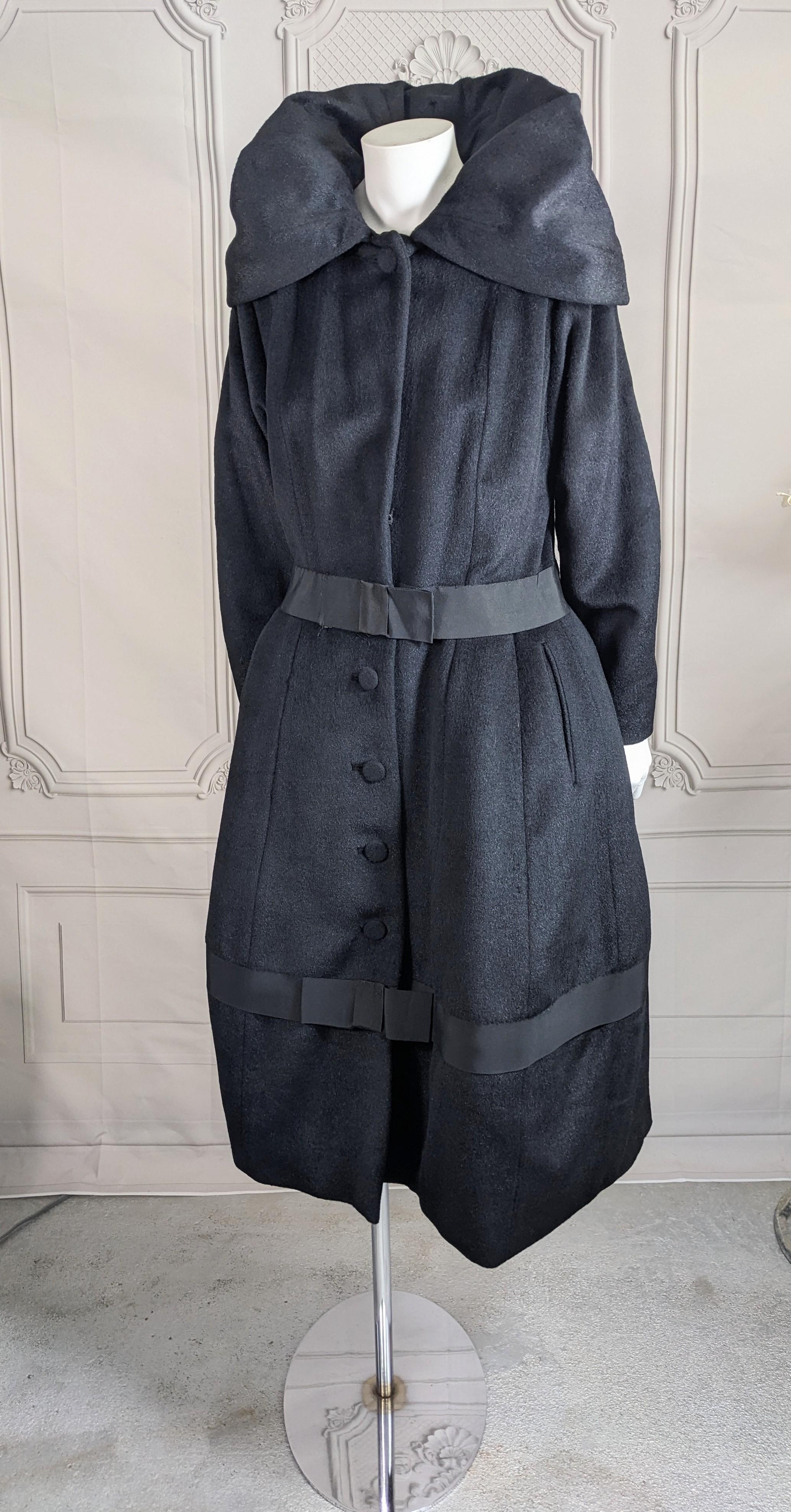 Erstaunlich Lilli Ann Edwardian inspiriert Laterne Mantel in tiefschwarz Robbenfell wie Wolle. Geschlossen zu tragen, mit hohem, getuftetem Kragen und laternenförmigem Rockteil für eine maximale Wirkung. Weiche, glatte Wolle mit Ripsbandbesatz an