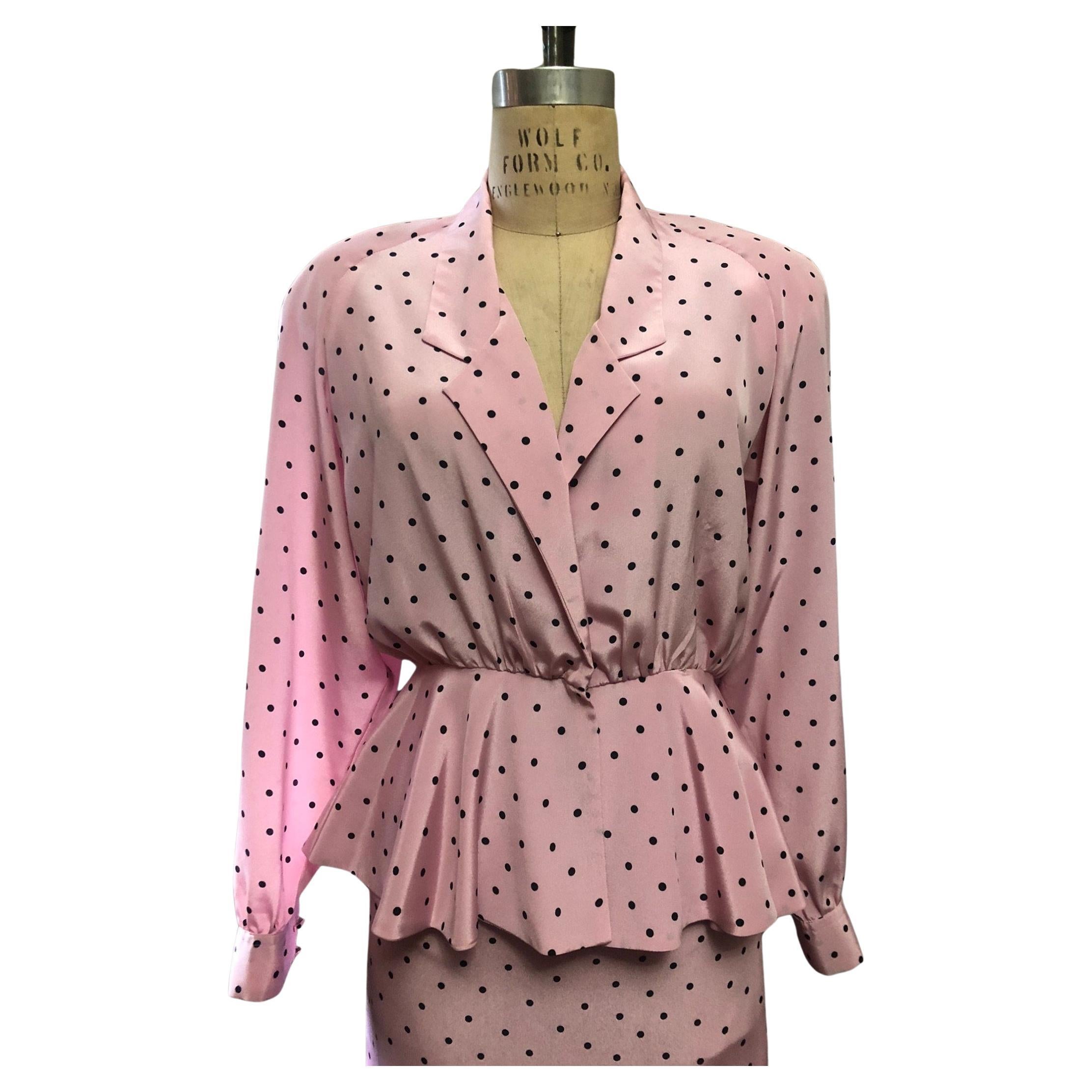 Vintage Lilli Ann pink and black polka dot two piece suit. long sleeve wrap style peplum blouse. knee length pencil skirt. partially elasticized waist. back zip closure.

Circa 1980s
Adolph Schuman for Lilli Ann
Pink/Black
Excellent Condition
Dry