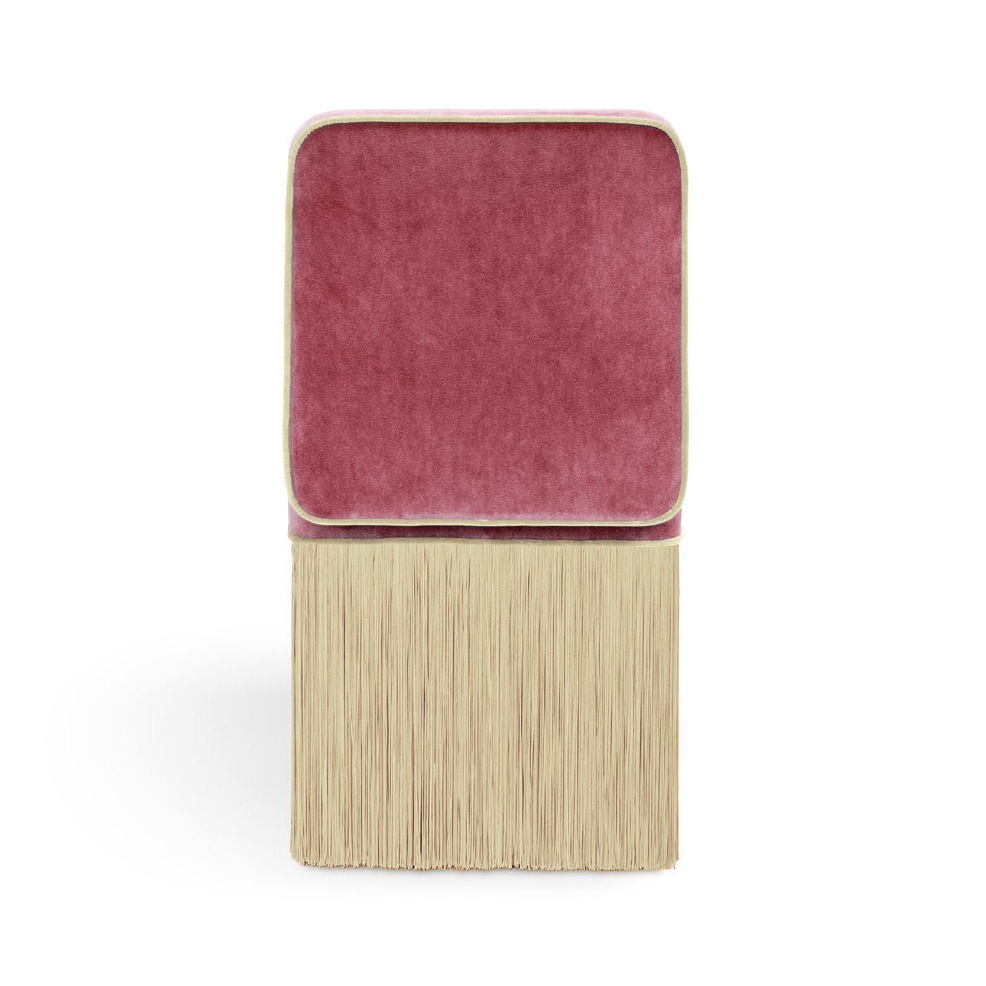 Designed by Lorenza Bozzoli, the Lilli chair combines luxury and versatility effortlessly. Upholstered in plush pink velvet with creamy beige piping and monochrome fringes, it exudes a stylish charm. Engineered for comfort with excellent lower back