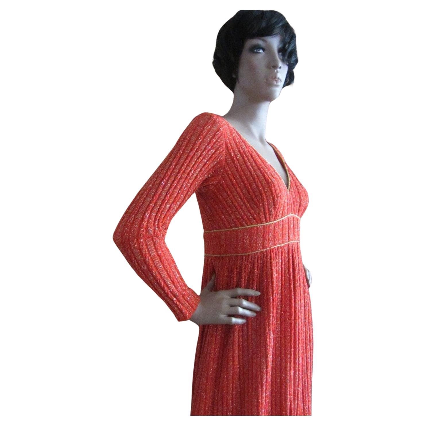 Vintage Lillie Rubin ribbed knit dress. A gorgeous & fiery shade of orange. Metallic gold lurex thread throughout. Vneck collar & long sleeves. Gold piping along neckline & waist. Inverted pleating at center front and center back. Dress has back