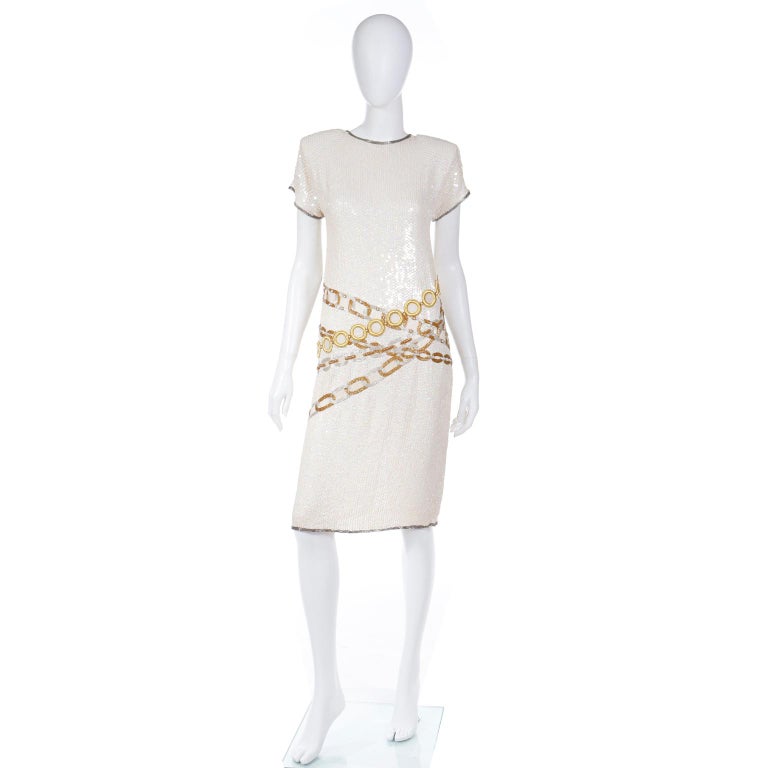 This unique vintage Lillie Rubin Vintage silk dress is fully covered in iridescent ivory sequins. The dress has incredible gold embroidered and copper and silver beaded faux chain link belts that crisscross the waist to the hips. There is also gold