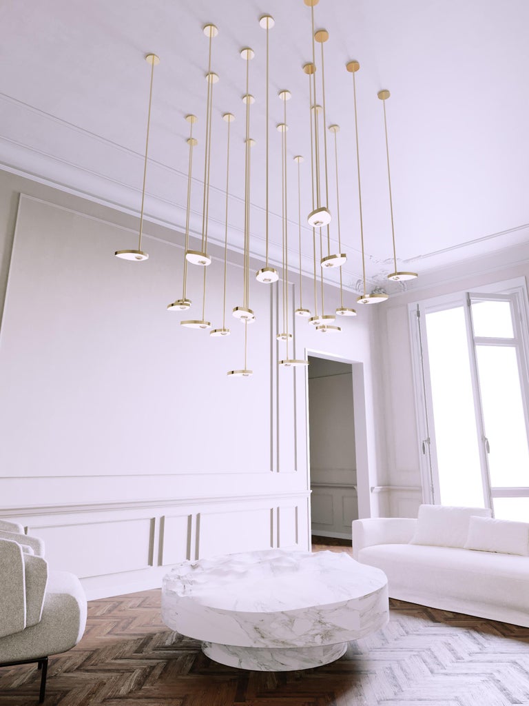 Lilly is a contemporary chandelier that challenges the differentiation of room and object. Formed from solid brass milled petals, each LED light source contains a single crystal hemisphere, absorbing and reflecting its environment to make it a part