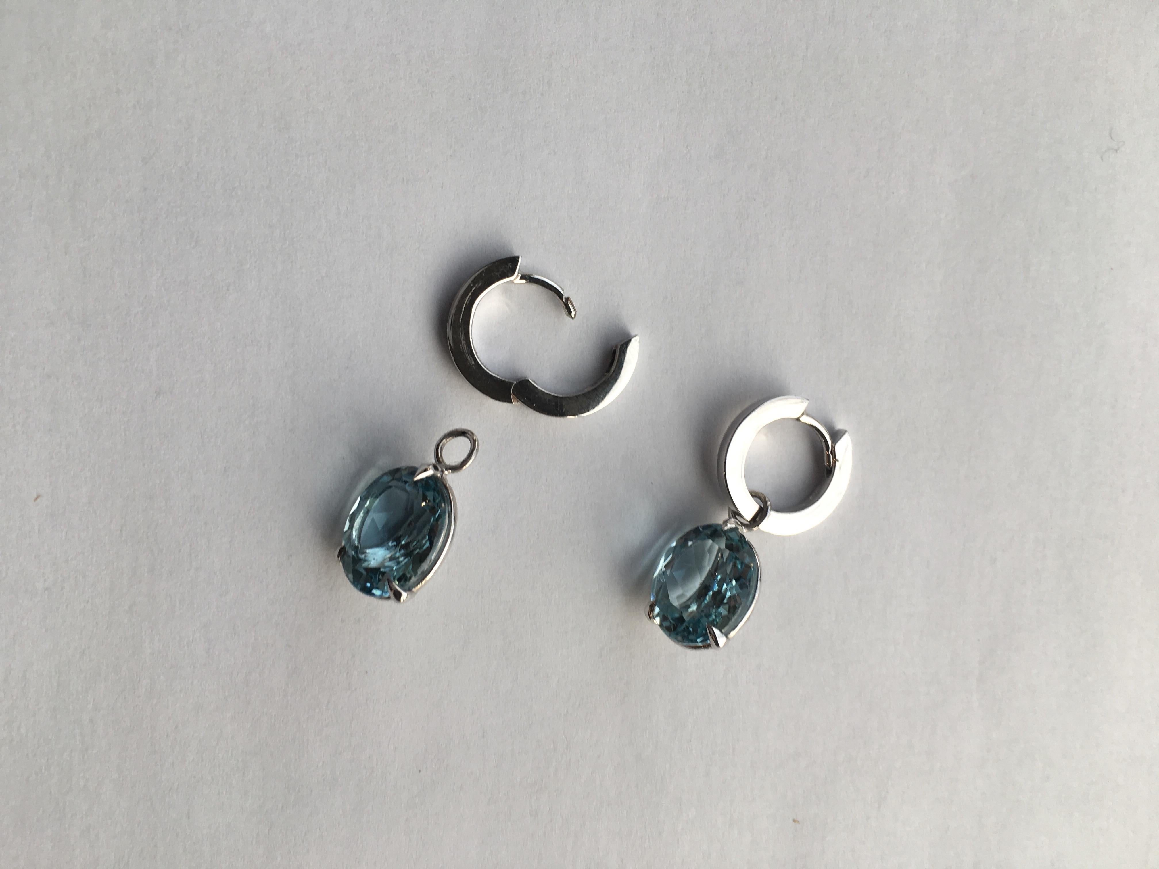 A pair of beautiful oval faceted aquamarine earrings. A splendid blue oval aquamarine hangs from a pair of round hoops in 18 Karat white gold. 

The aquamarines are detachable so you can wear the hoops on their own or with other gemstones or pearls.