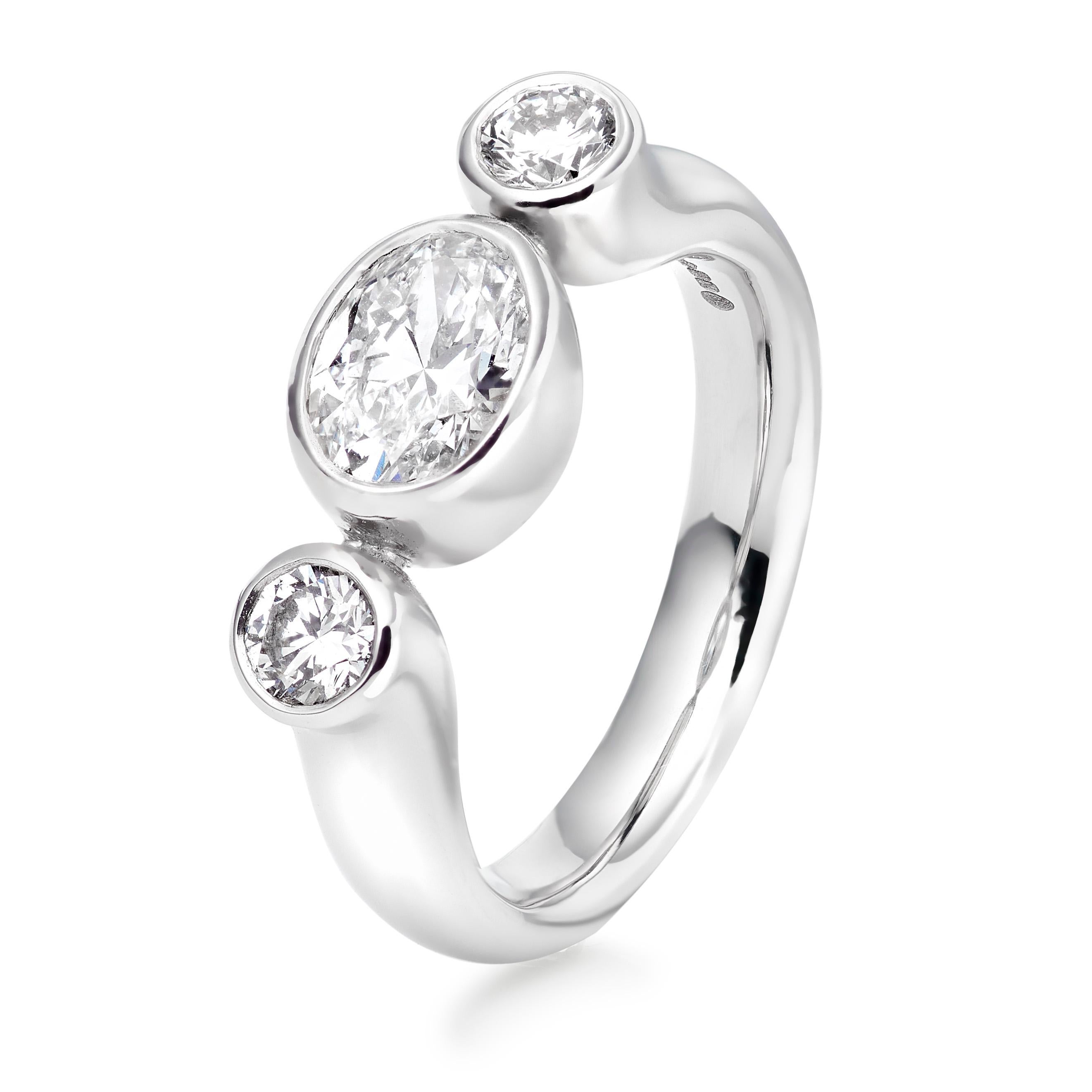 The Bon Bon is one of Lilly Hastedt's signature rings. The design of this ring follows the roundness of the gemstones. It is a modern version of a three stone ring with a central oval diamond paired with sparkling round diamonds on either side.