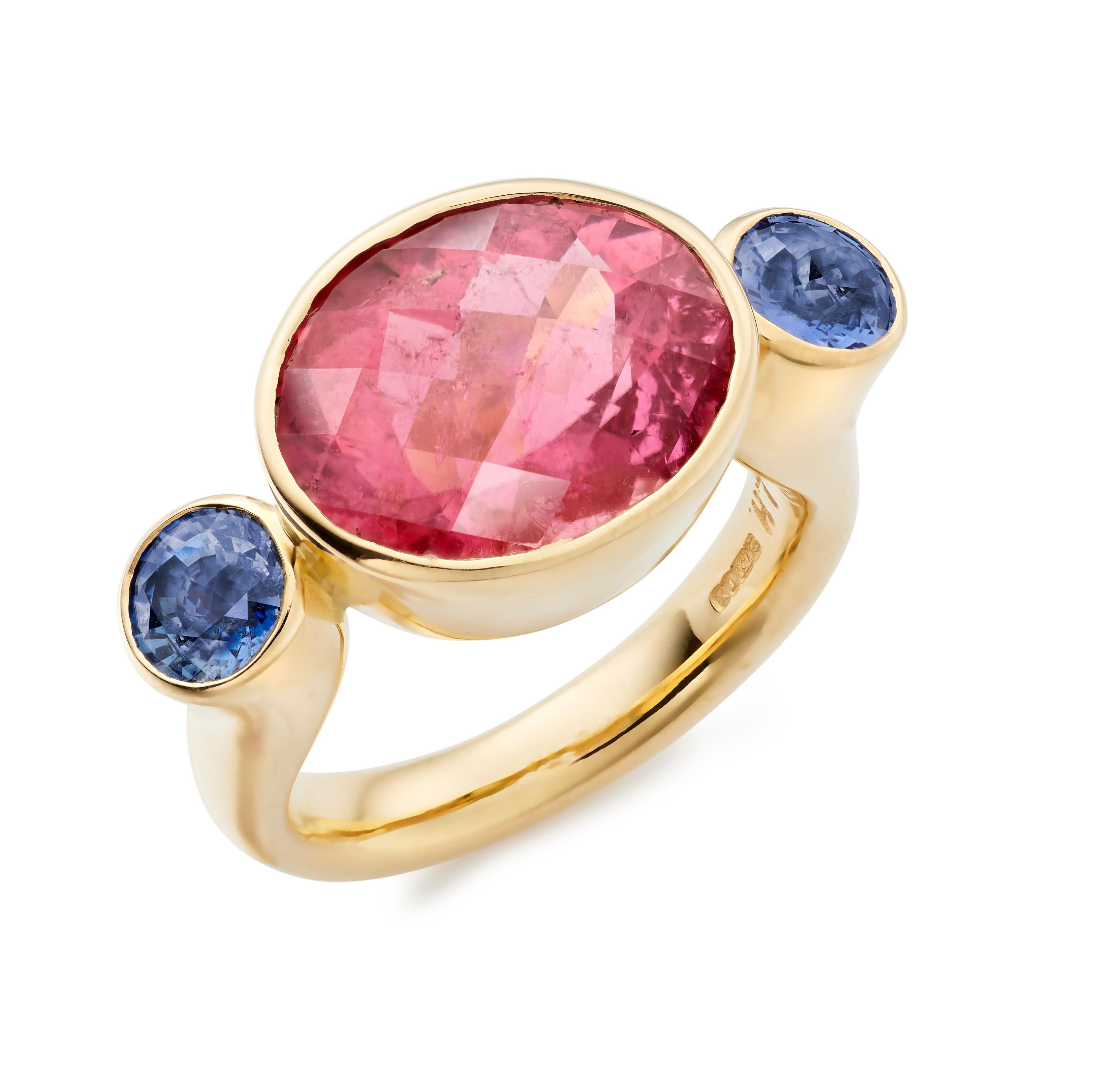 Der Bon Bon ist einer der charakteristischen Ringe von Lilly Hastedt. Das Design dieses Rings folgt der Rundung der Edelsteine. Der zentrale pinkfarbene Turmalin hat einen schachbrettartigen Facettenschliff und ist mit runden Tansaniten gepaart.