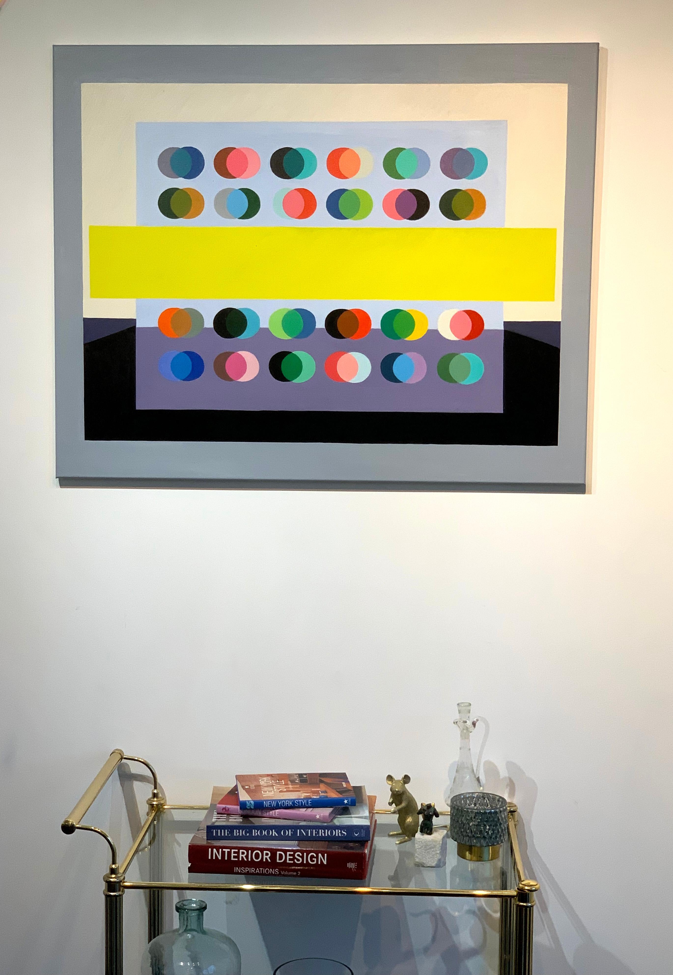 Dream Big is an original oil painting, where colorful circles are inter-lapping on top of a grey color plane, surrounded by a black and grey landscape plain. The middle is a bright neon yellow square. Turning this into a very contemporary
