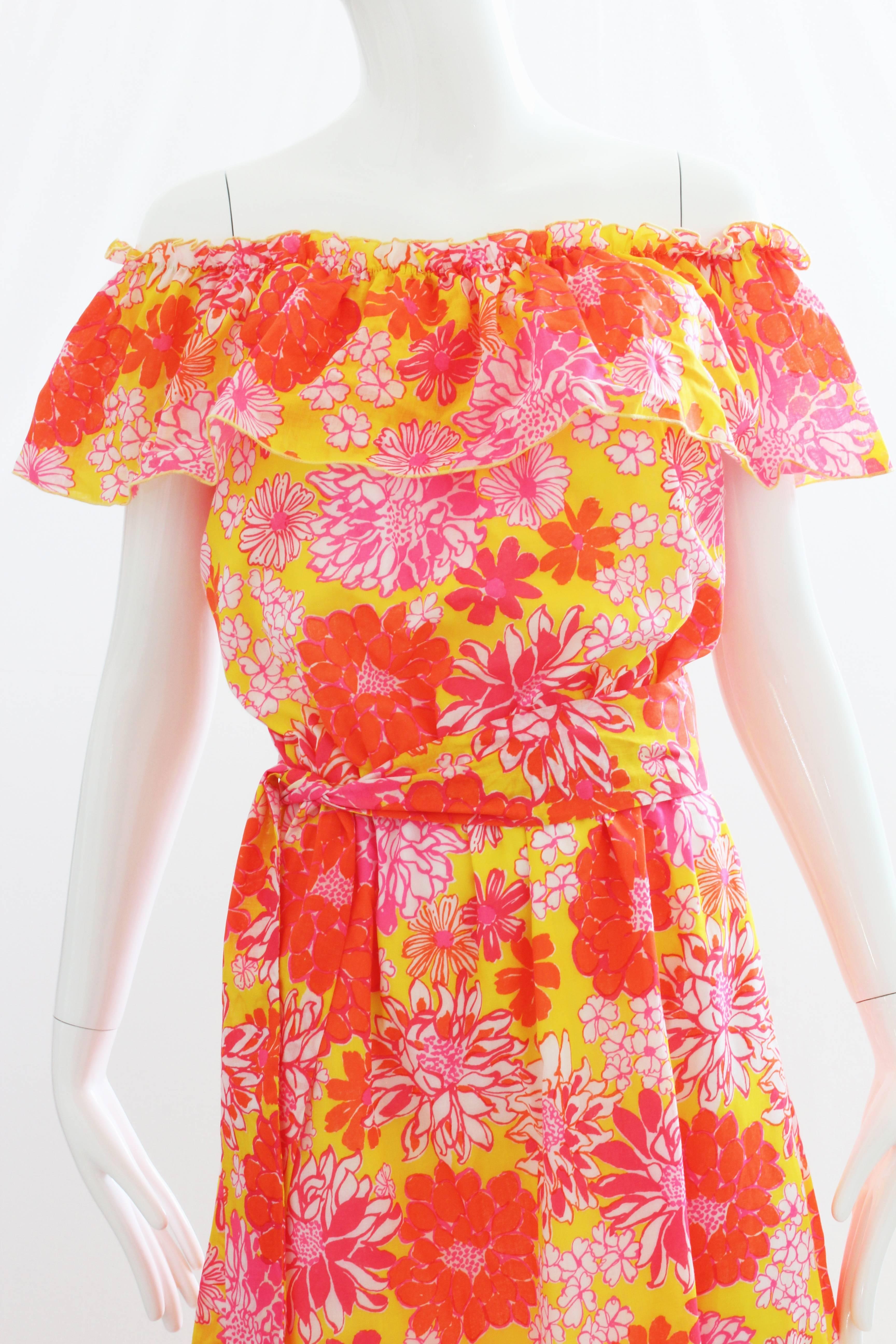 This vibrant print dress was made in the 70s by Lilly Pulitzer for her more youthful LIZA line, named after her daughter. Made from a cotton poly blend, it features a ruffled collar that sits off the shoulder, a full-maxi skirt and a matching belt.