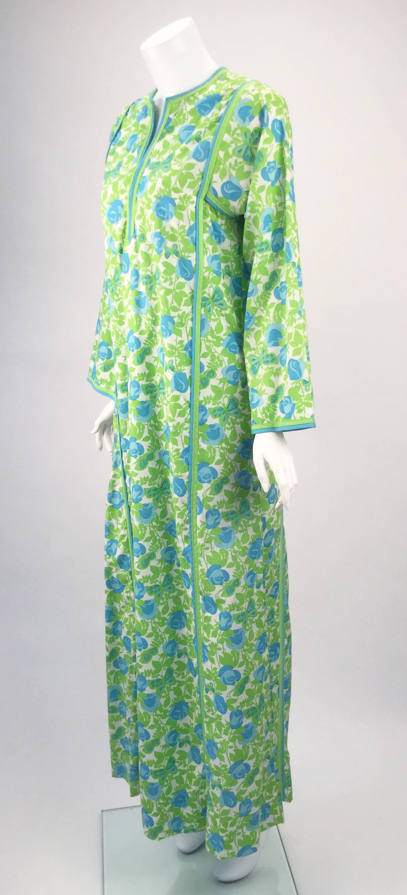 Fun, fun, fun... late 1960s/early 1970s multi green and blue floral and butterfly print, long sleeve caftan by Lilly Pulitzer. This cotton caftan has a deep slot neckline, which fastens by a single hook and eye halfway down the slot. Seam binding