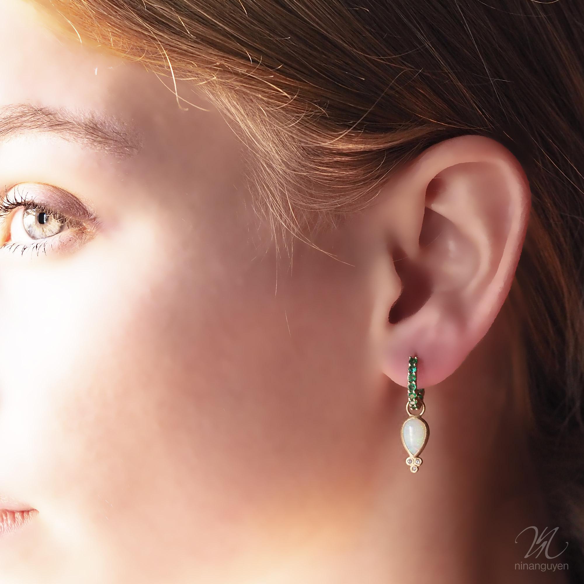 Designed with bezel-set white opal stones, the diamond-accented Lilly Gold Jackets embrace the shape of a drop of water—an essential element for life—and bring a little edge to any of our hoop styles.

Stone carat: 2.8
Diamond carat: 0.045