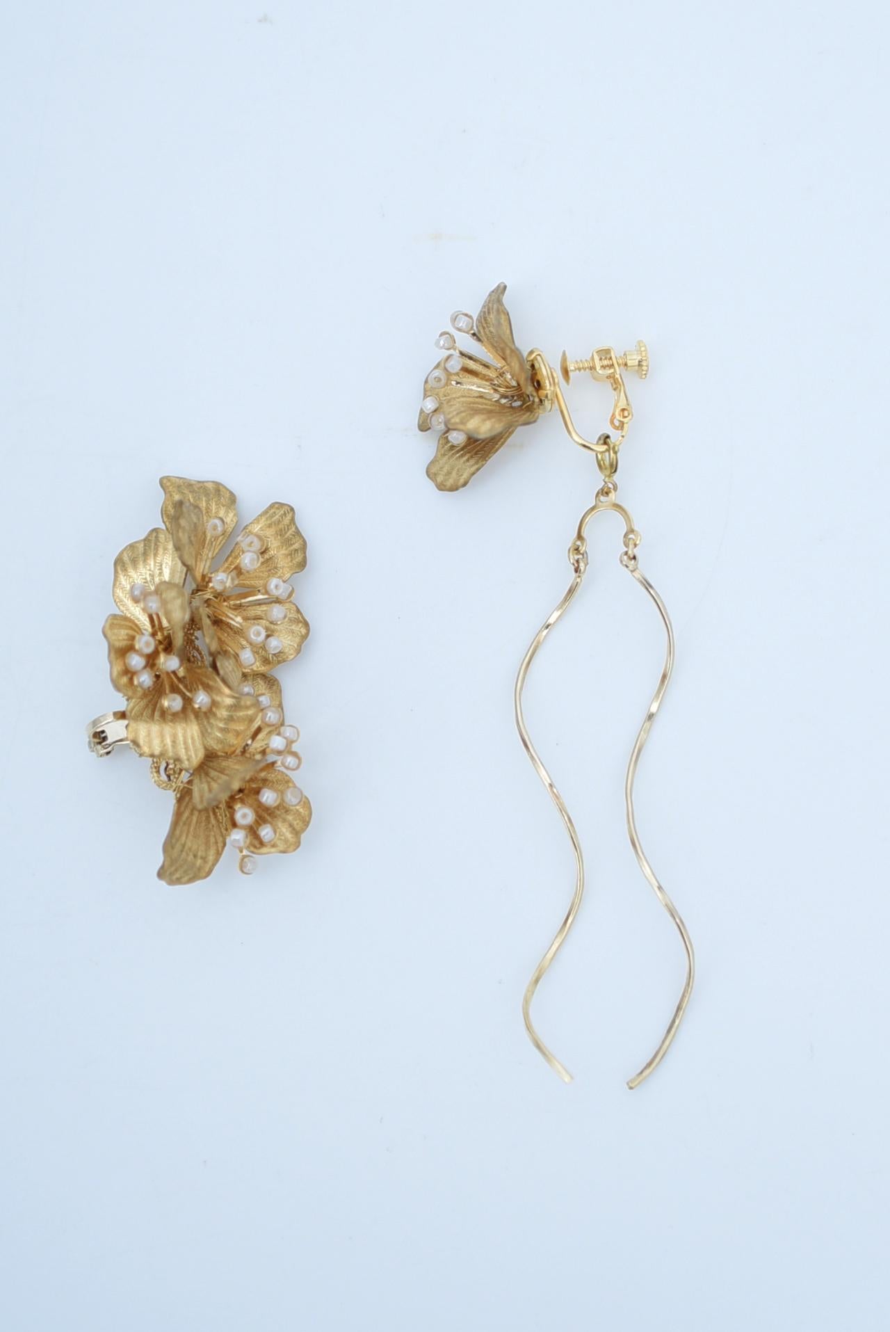 material:brass,glass beads
size:length 7cm


A very gorgeous item that can cover the entire ear.
The hanging line looks like a spiral and sparkles in different light conditions.
It is 2-way and can be used without the line.